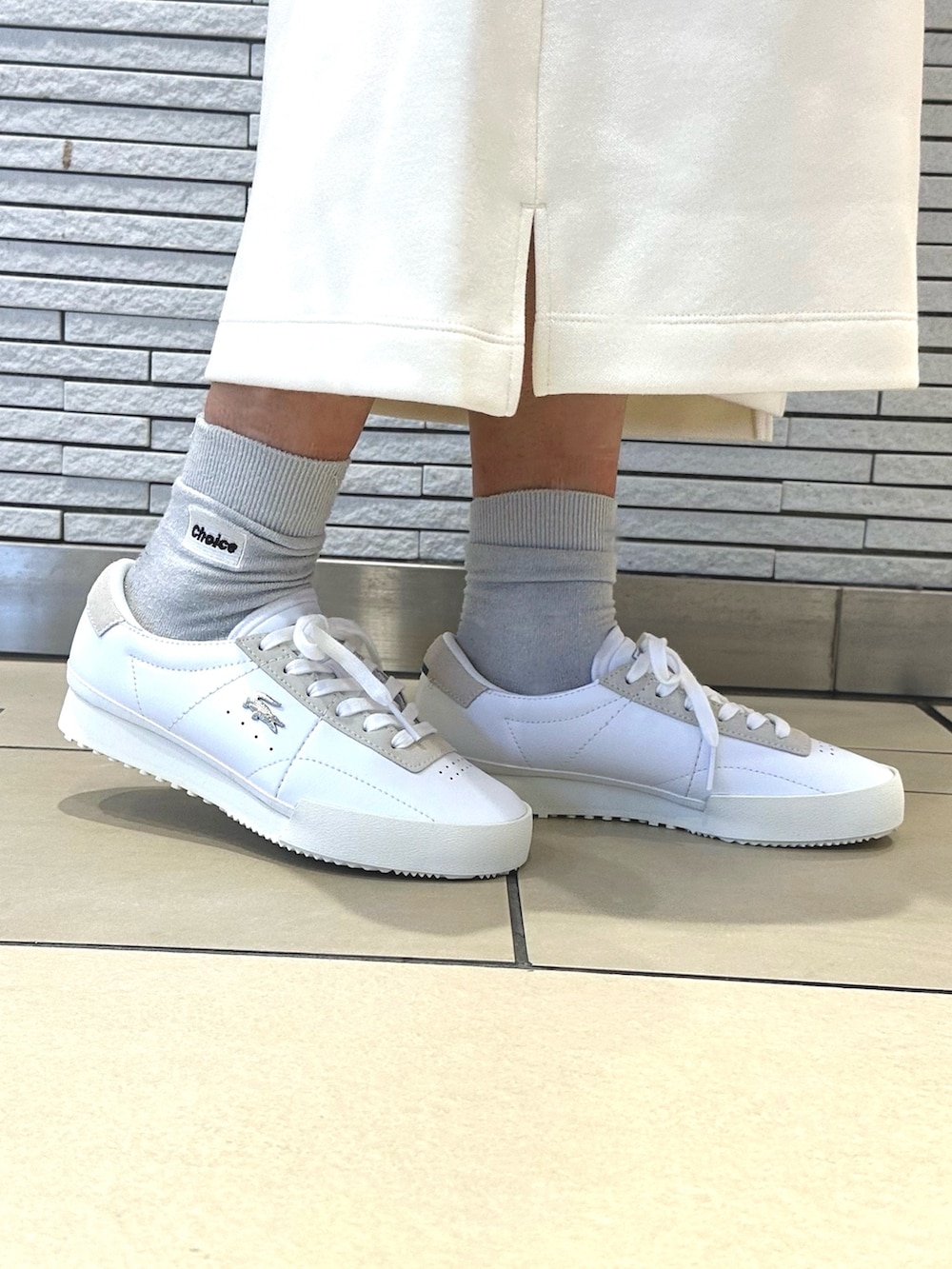 ブラウン系のダウンジャケット/コート、ホワイト系のワンピース、シルバー系のショルダーバッグを着用したレディースの秋コーディネートの5枚目の写真