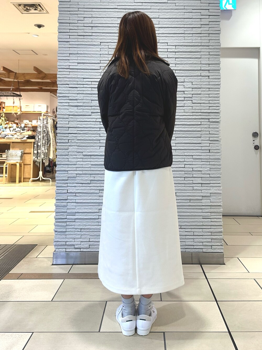 ブラウン系のダウンジャケット/コート、ホワイト系のワンピース、シルバー系のショルダーバッグを着用したレディースの秋コーディネートの2枚目の写真