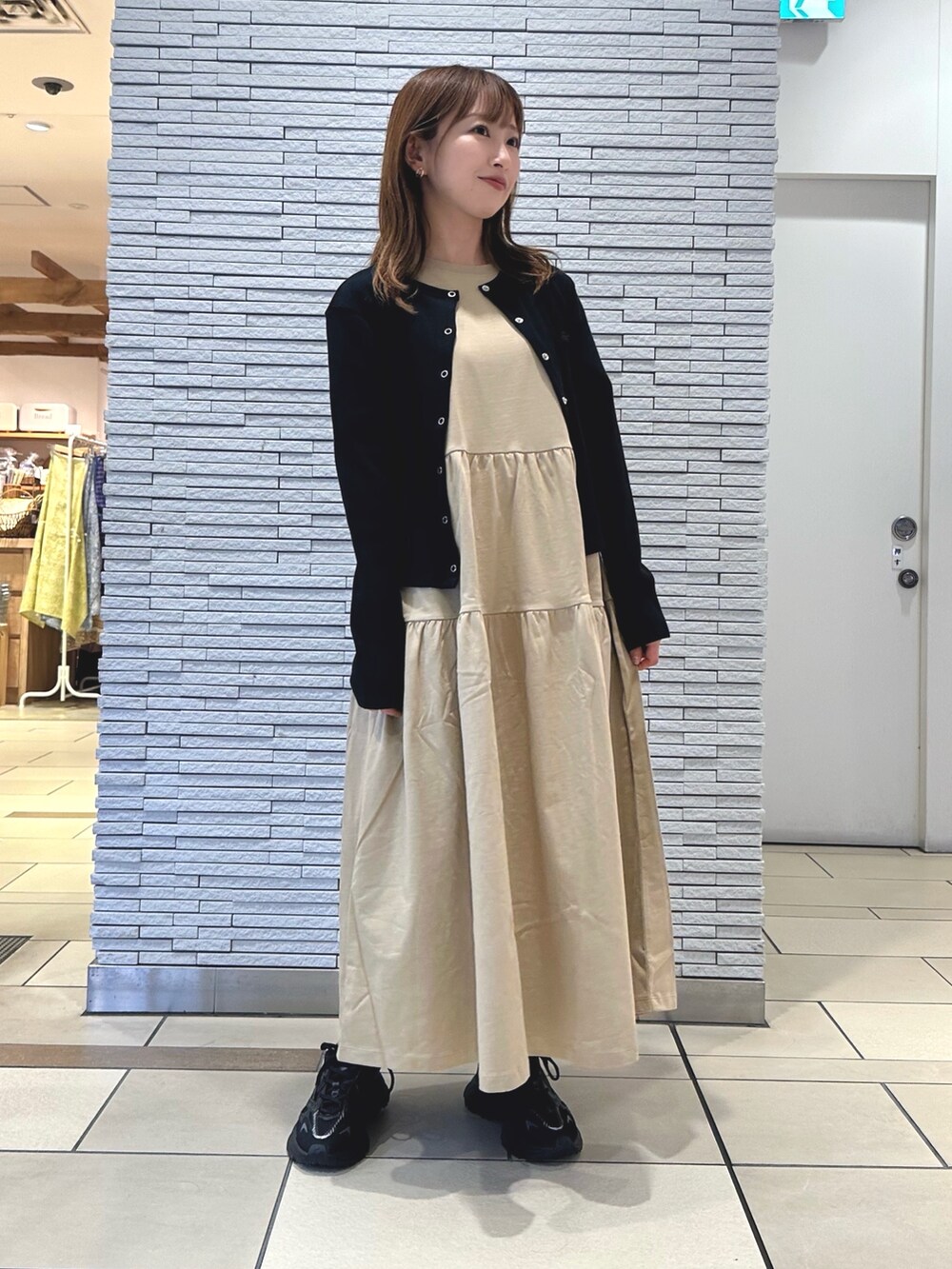 ベージュ系のワンピース、ブラック系のカーディガン/ボレロ、ブラック系のショルダーバッグを着用したレディースの夏コーディネートの4枚目の写真