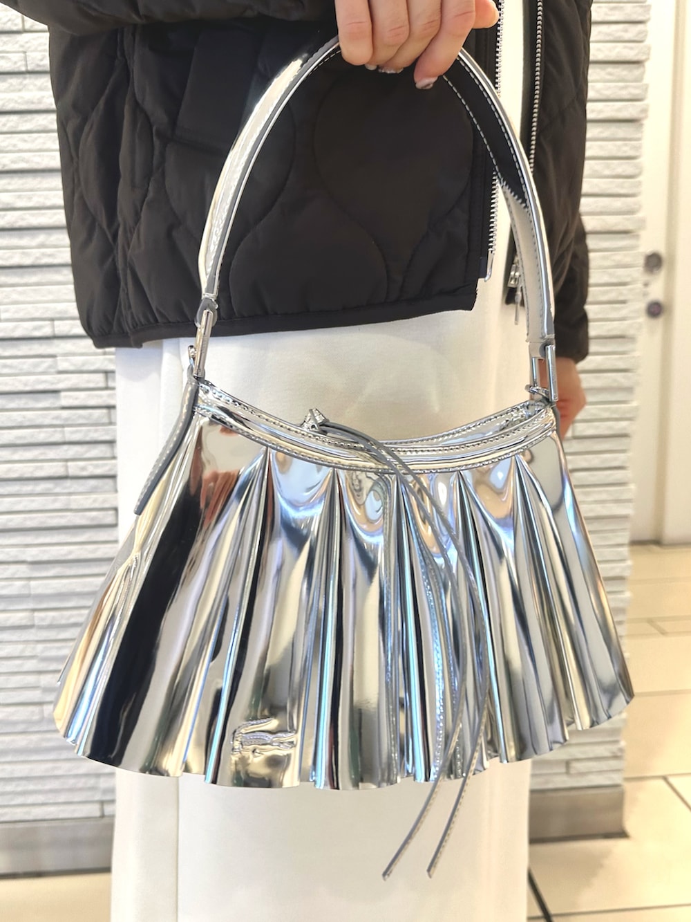 ブラウン系のダウンジャケット/コート、ホワイト系のワンピース、シルバー系のショルダーバッグを着用したレディースの秋コーディネートの4枚目の写真