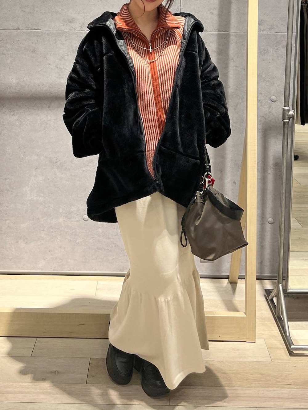 ブラウン系のショルダーバッグ、ホワイト系のスカート、オレンジ系のカーディガン/ボレロを着用したレディースの秋コーディネートの5枚目の写真