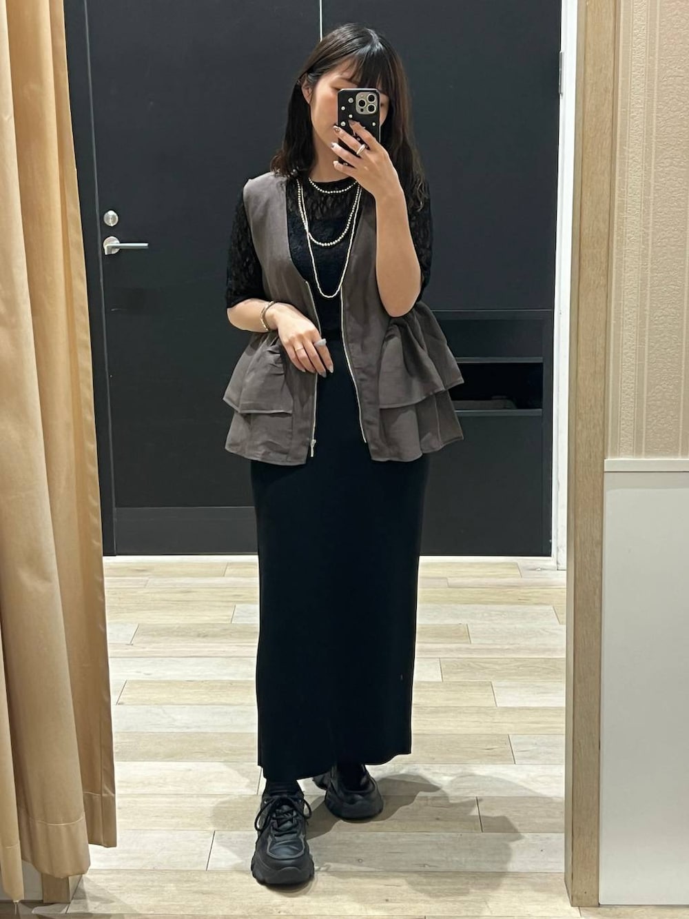 ブラック系のスカート、ブラウン系のベスト、ブラック系のTシャツ/カットソーを着用したレディースの春コーディネートの5枚目の写真