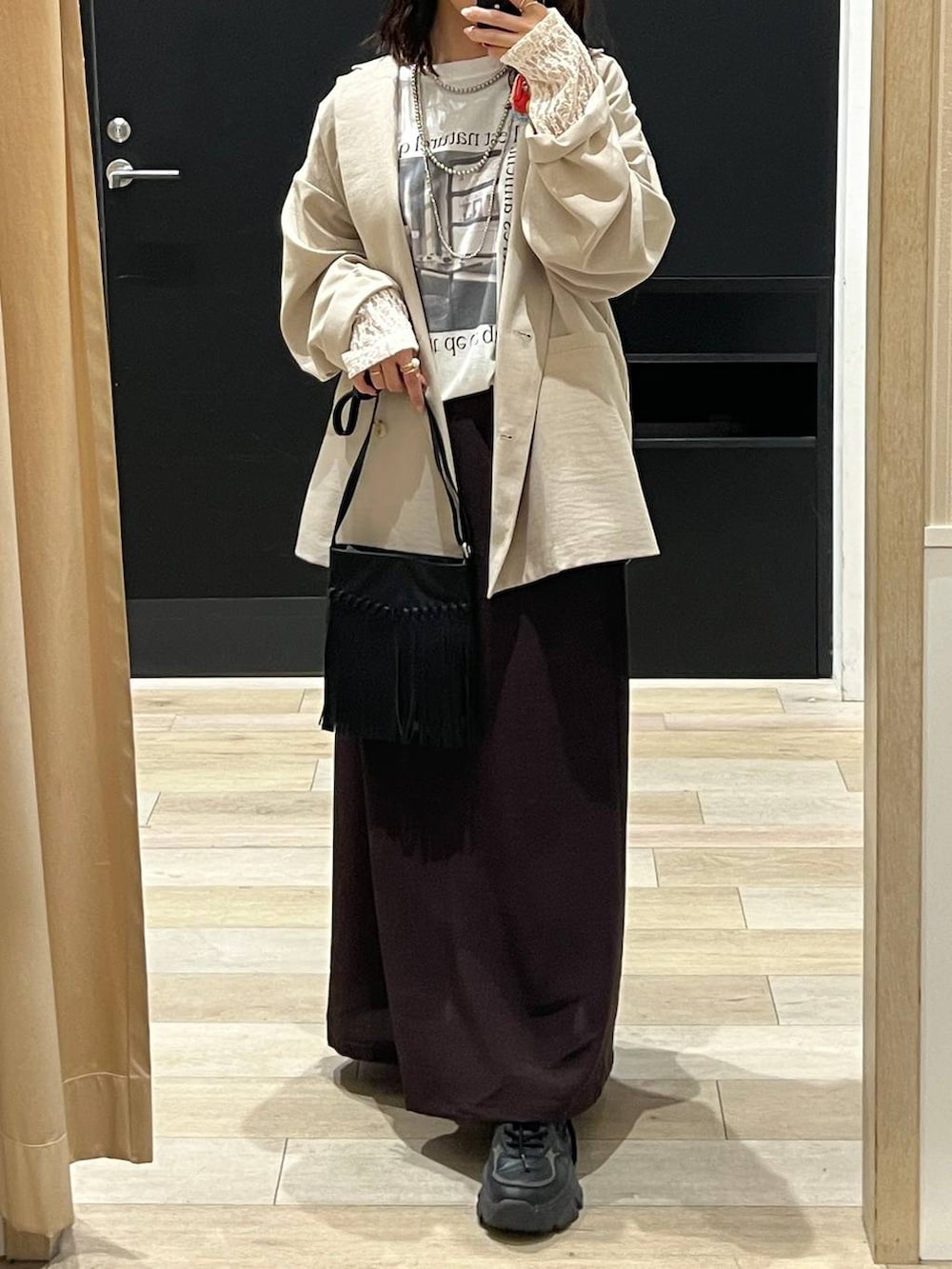 ブラック系のショルダーバッグ、ブラウン系のスカート、ホワイト系のTシャツ/カットソーを着用したレディースの春コーディネートの3枚目の写真