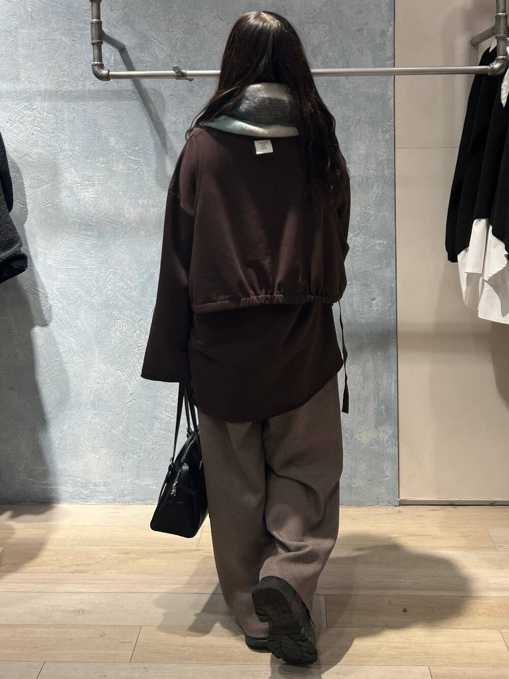 ブラック系のボストンバッグ、ブラウン系のスウェット、ブラウン系のその他パンツを着用したレディースの冬コーディネートの3枚目の写真