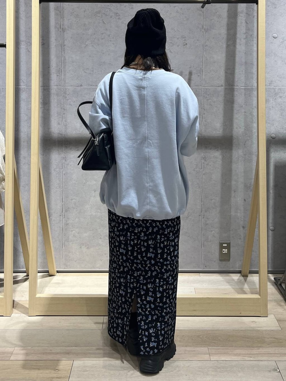 ブラック系のボストンバッグ、ブラック系のスカート、ブルー系のTシャツ/カットソーを着用したレディースの冬コーディネートの3枚目の写真