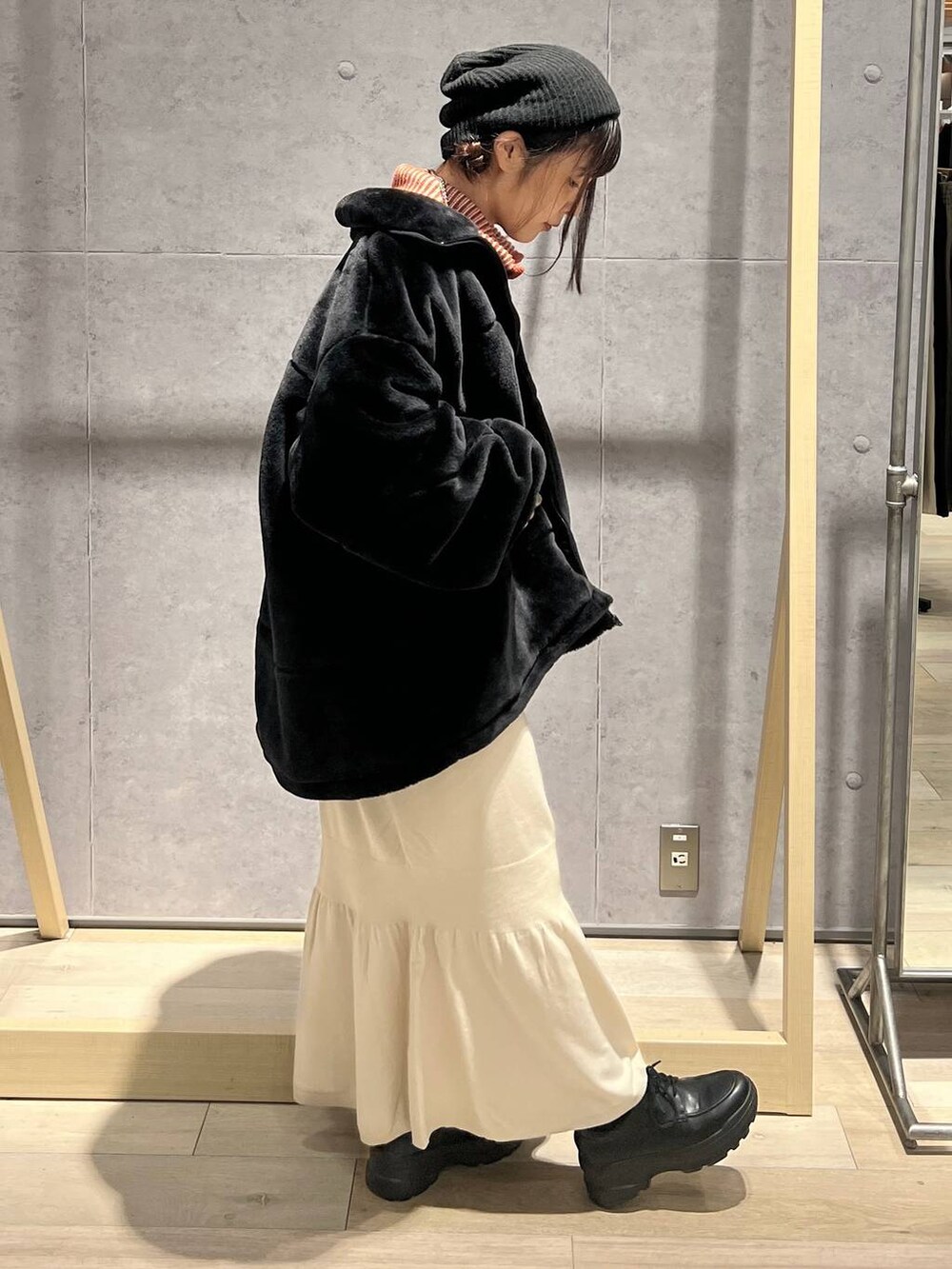 ブラウン系のショルダーバッグ、ホワイト系のスカート、オレンジ系のカーディガン/ボレロを着用したレディースの秋コーディネートの2枚目の写真