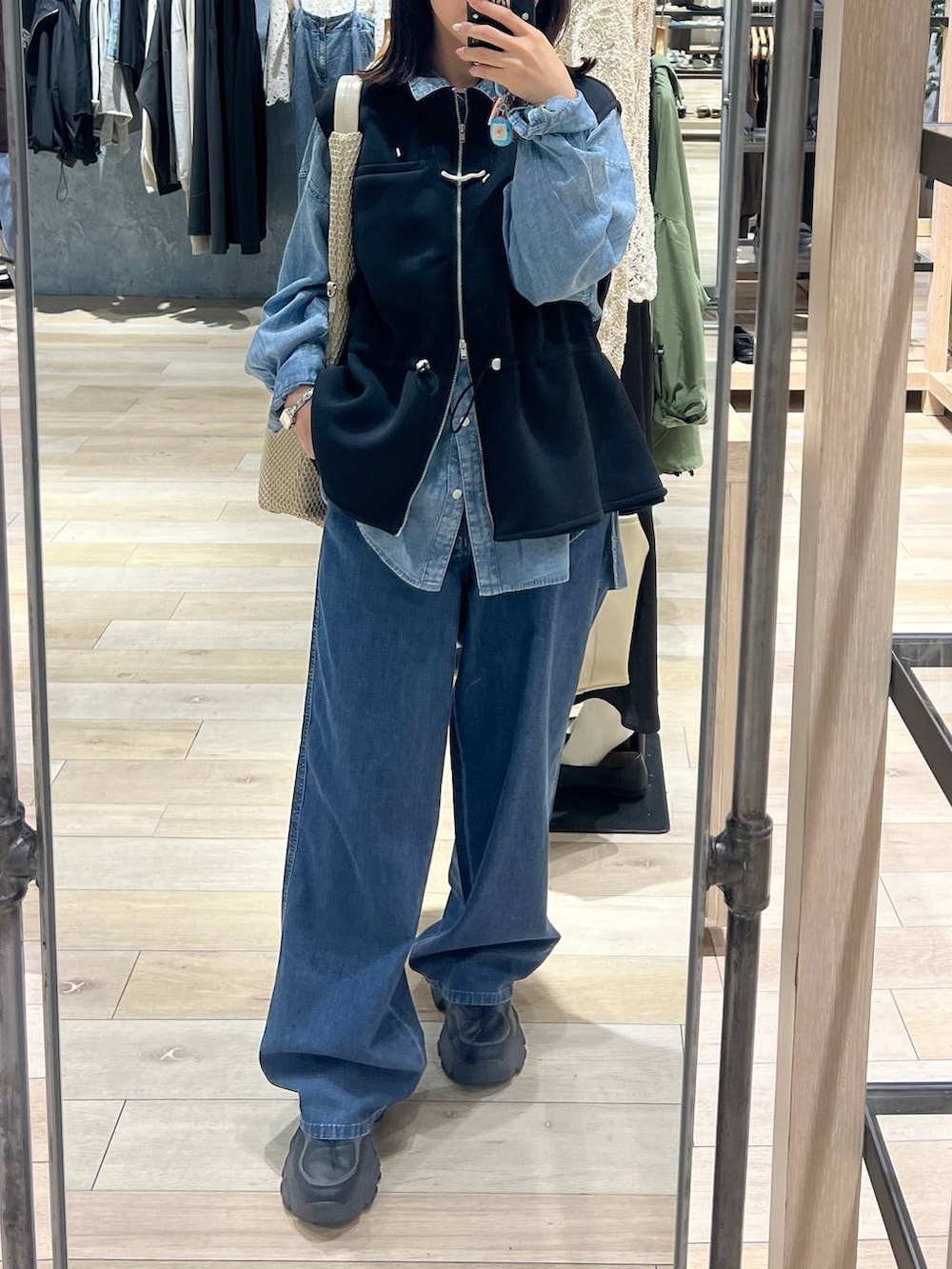 ブルー系のデニムパンツ、ブルー系のシャツ/ブラウス、ブラック系のベストを着用したレディースの春コーディネートの3枚目の写真