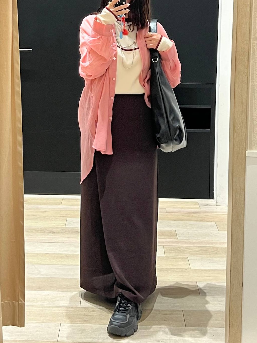 ピンク系のシャツ/ブラウス、ブラウン系のスカート、ブラック系のショルダーバッグを着用したレディースの春コーディネートの3枚目の写真