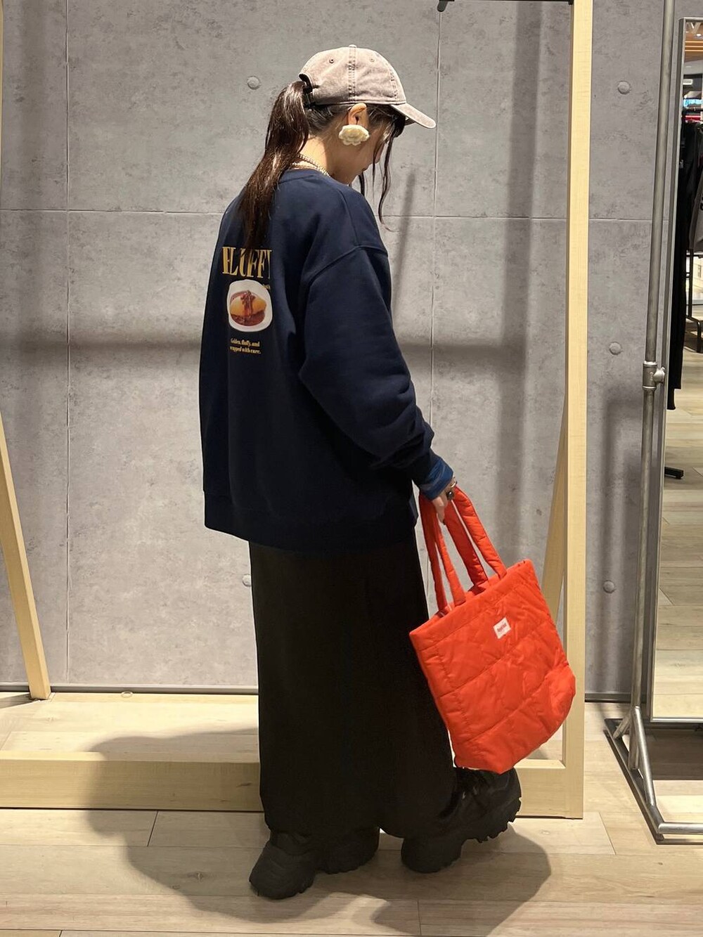 ブラック系のTシャツ/カットソー、ブラック系のスカート、ブルー系のスウェットを着用したレディースの秋コーディネートの6枚目の写真