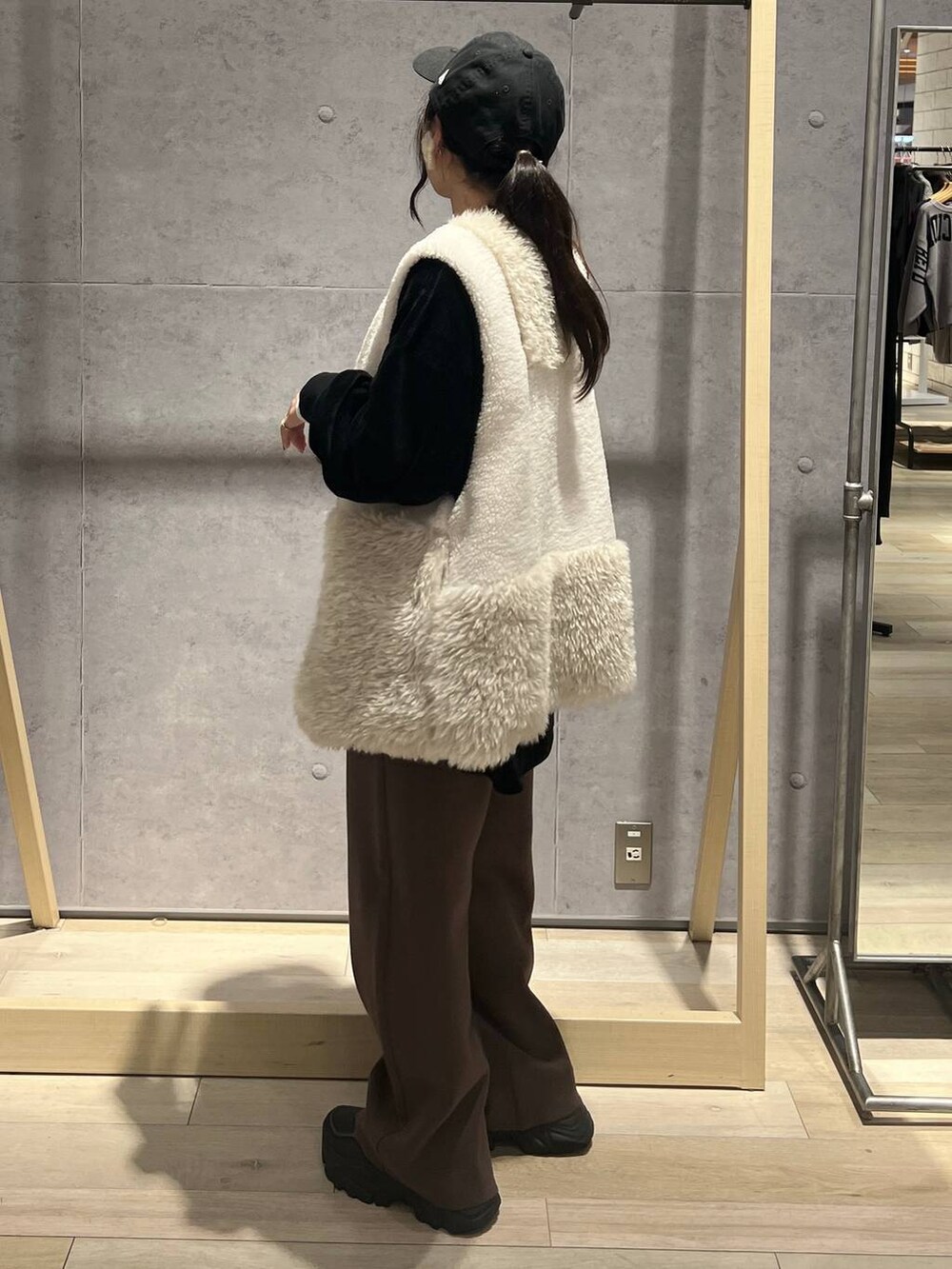 ブラウン系のその他パンツ、ホワイト系のベスト、ブラック系のTシャツ/カットソーを着用したレディースの秋コーディネートの4枚目の写真