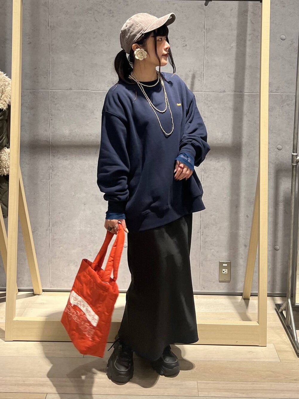 ブラック系のTシャツ/カットソー、ブラック系のスカート、ブルー系のスウェットを着用したレディースの秋コーディネートの3枚目の写真