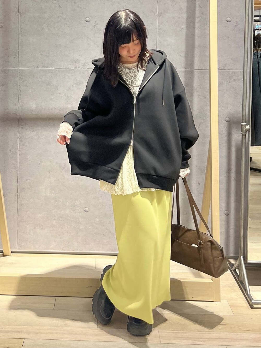 グリーン系のスカート、ブラック系のパーカー、ブラウン系のボストンバッグを着用したレディースの冬コーディネートの6枚目の写真