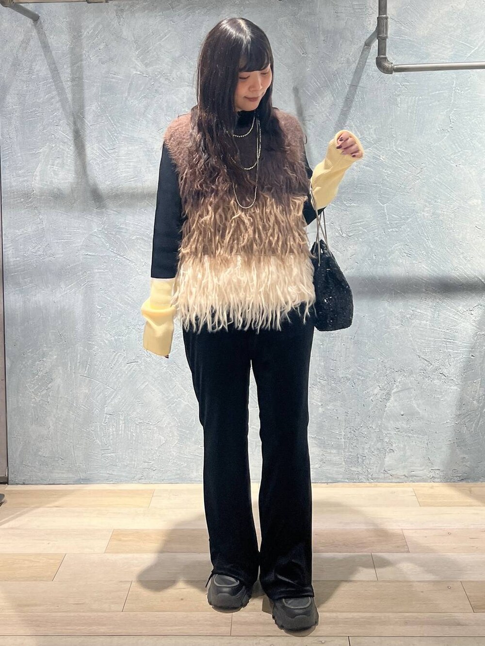 ブラック系のニット/セーター、ブラック系のその他パンツ、ブラック系のショルダーバッグを着用したレディースの冬コーディネートの3枚目の写真