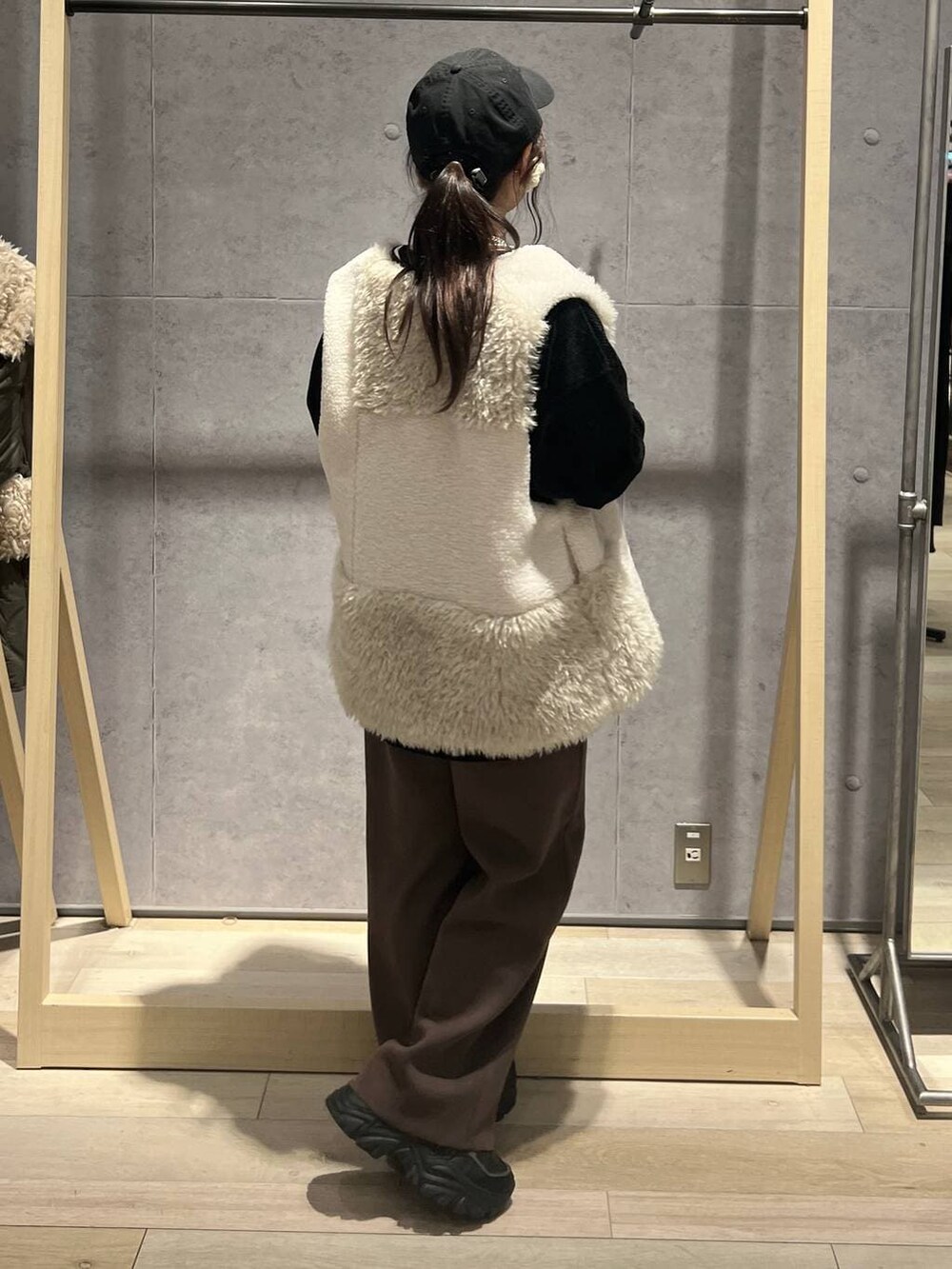 ブラウン系のその他パンツ、ホワイト系のベスト、ブラック系のTシャツ/カットソーを着用したレディースの秋コーディネートの3枚目の写真