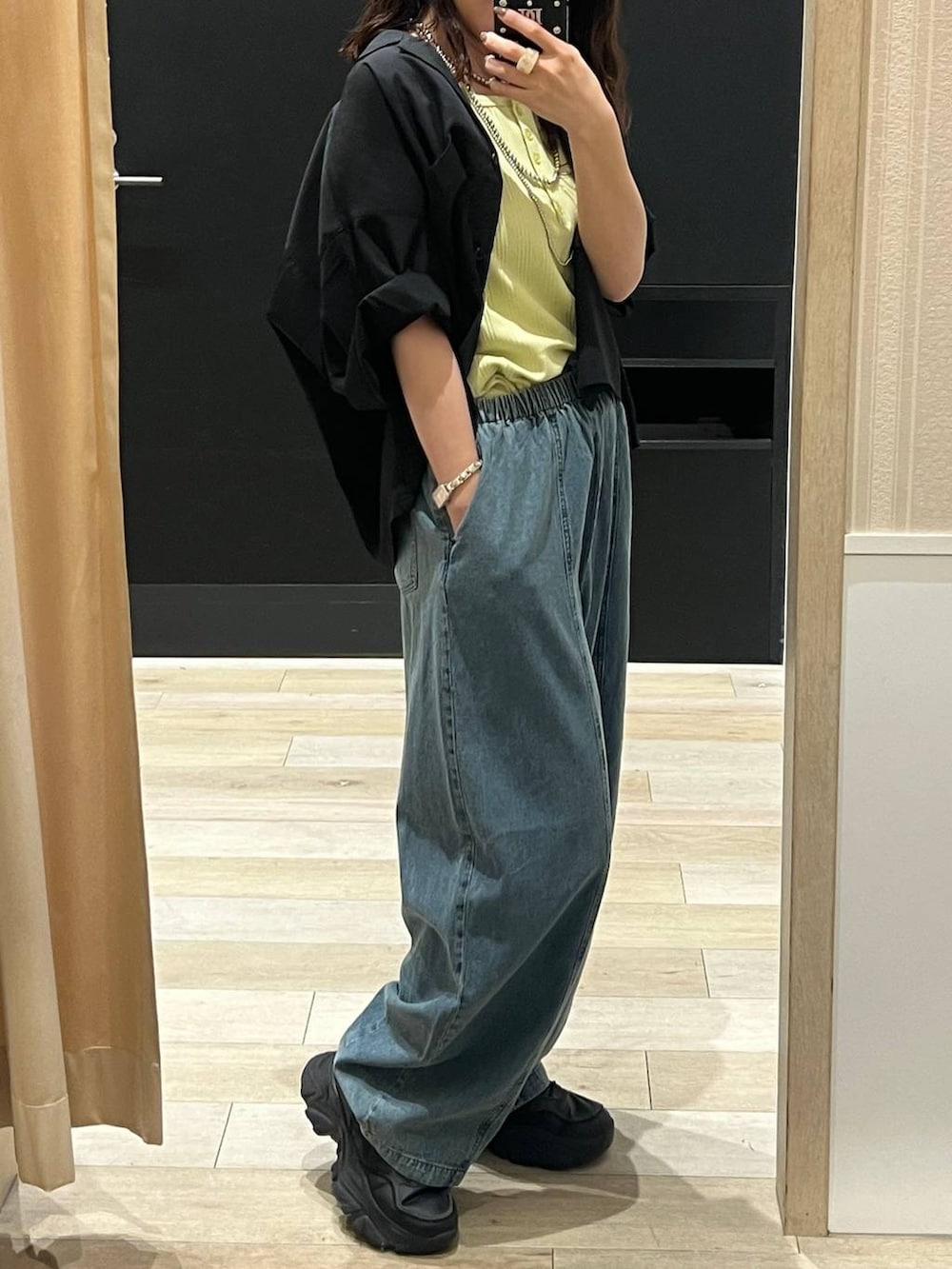 ブルー系のデニムパンツ、ブラック系のシャツ/ブラウス、シルバー系のネックレスを着用したレディースの春コーディネートの2枚目の写真