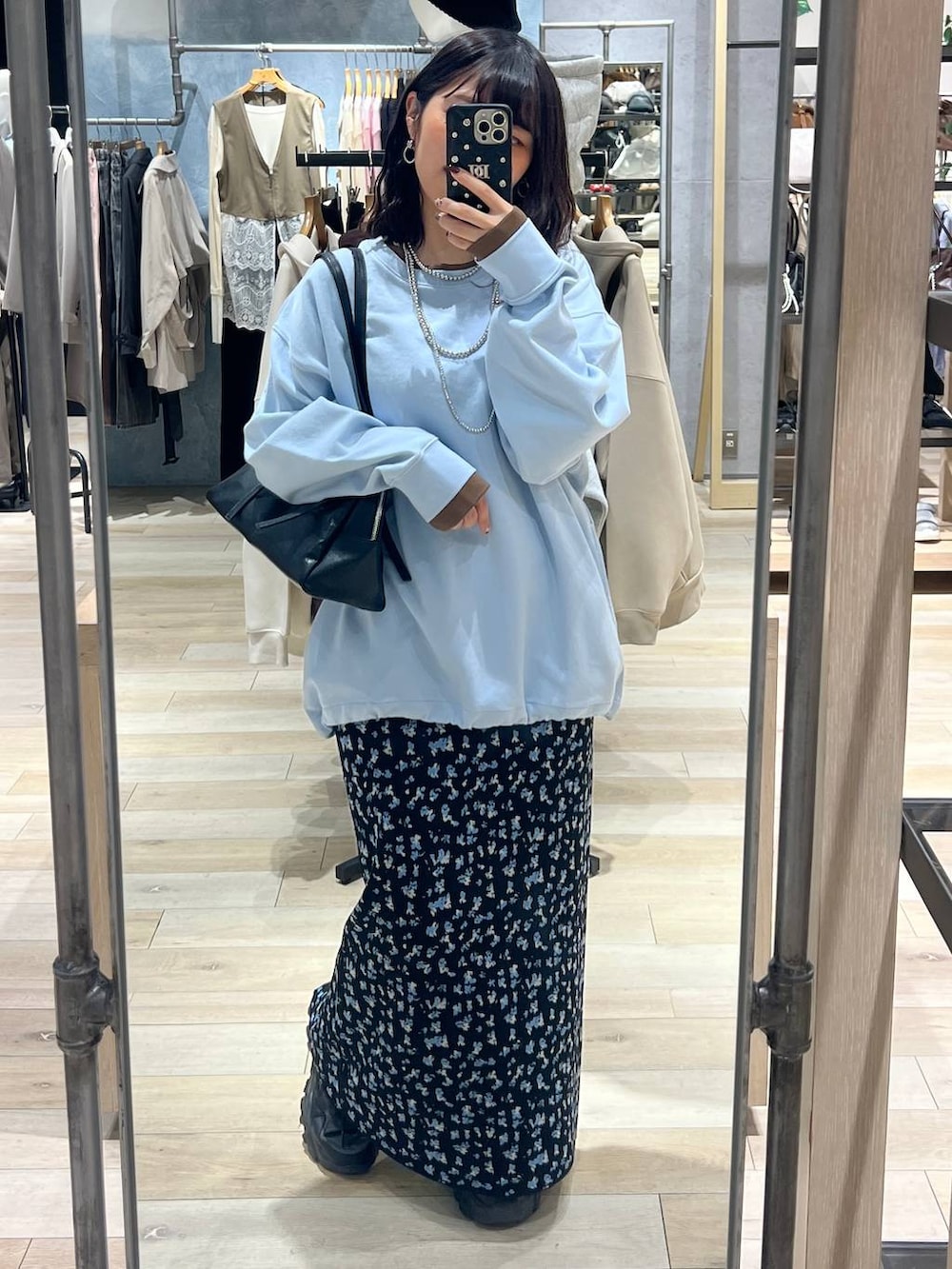 ブラック系のボストンバッグ、ブラック系のスカート、ブルー系のTシャツ/カットソーを着用したレディースの冬コーディネートの4枚目の写真