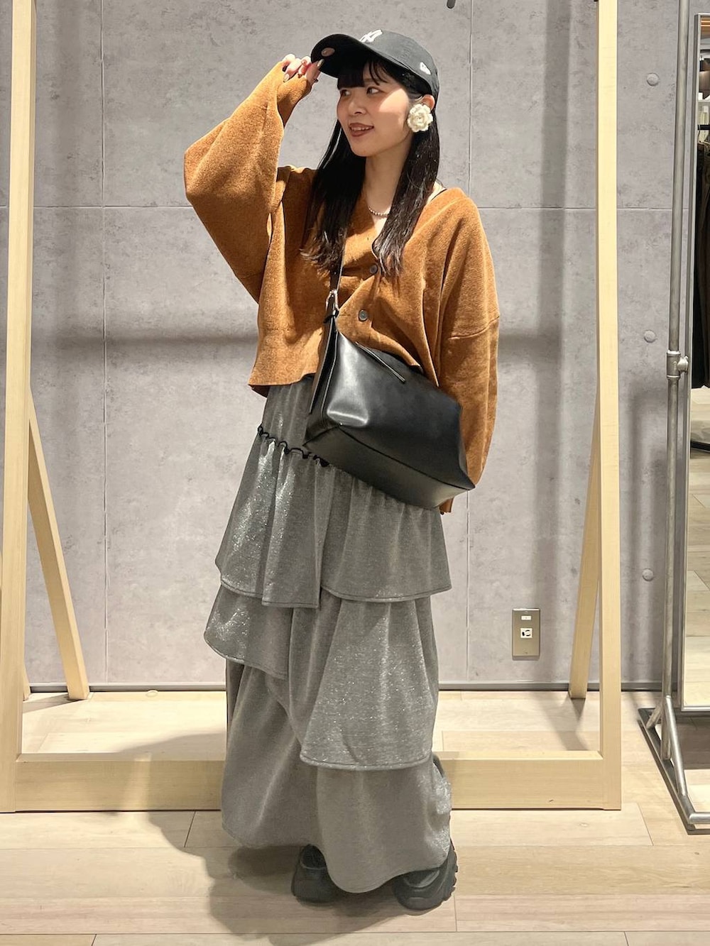 ブラック系のショルダーバッグ、イエロー系のカーディガン/ボレロ、グレー系のスカートを着用したレディースの秋コーディネートの4枚目の写真