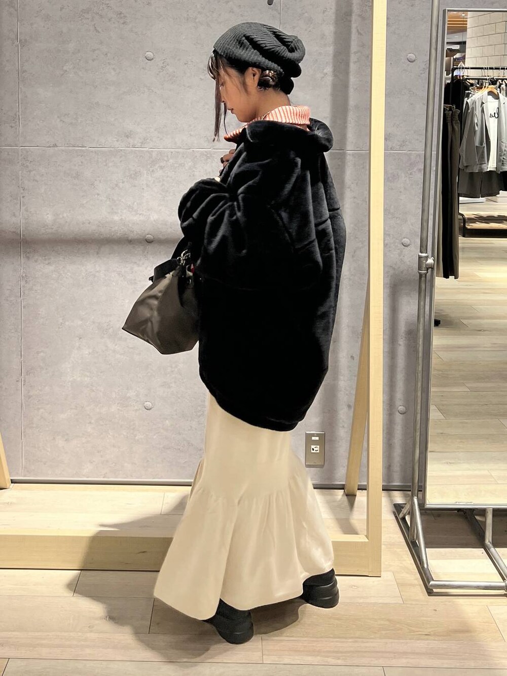 ブラウン系のショルダーバッグ、ホワイト系のスカート、オレンジ系のカーディガン/ボレロを着用したレディースの秋コーディネートの4枚目の写真