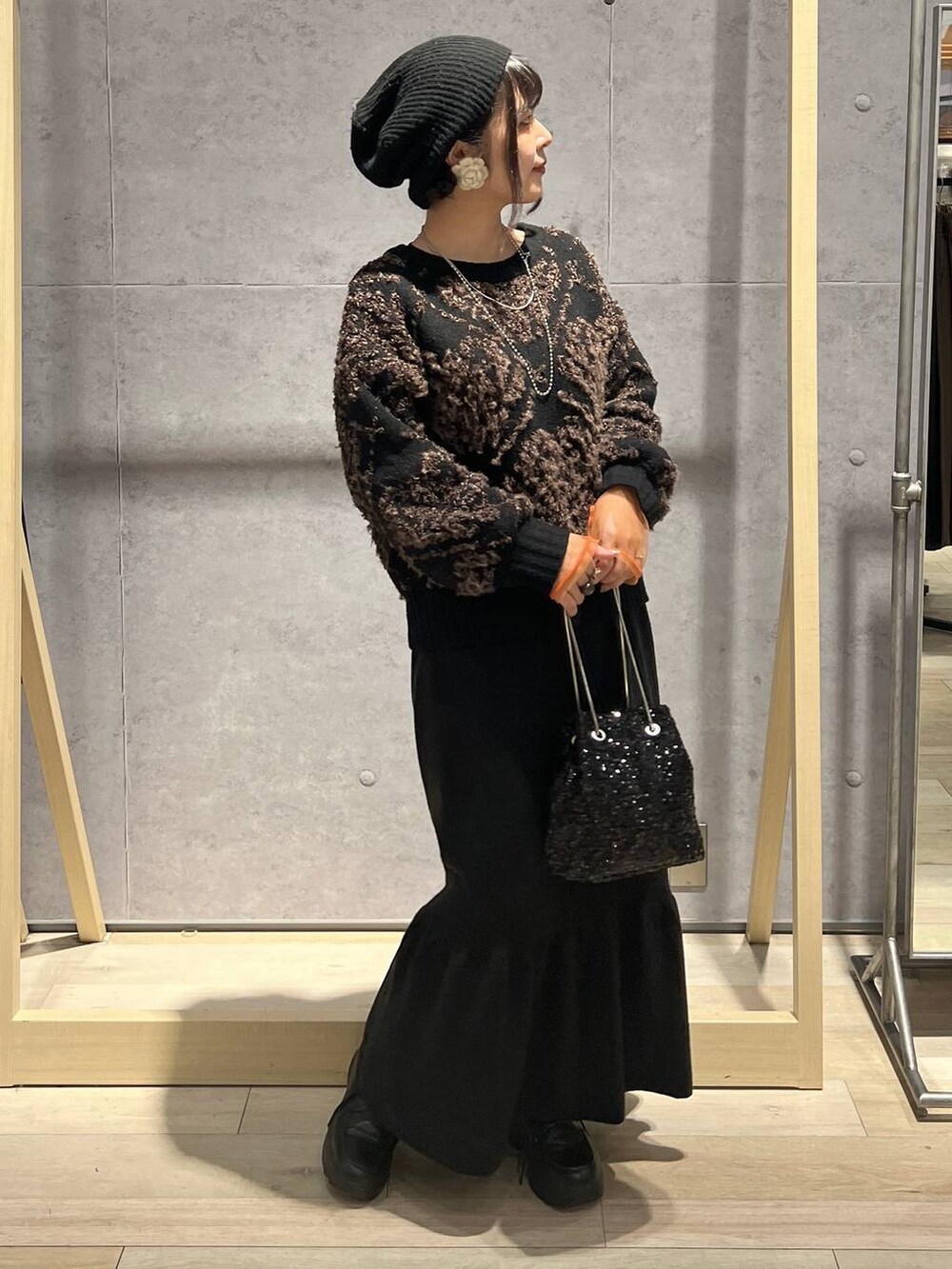 ブラック系のTシャツ/カットソー、ブラック系のスカート、ブラック系のショルダーバッグを着用したレディースの秋コーディネートの2枚目の写真