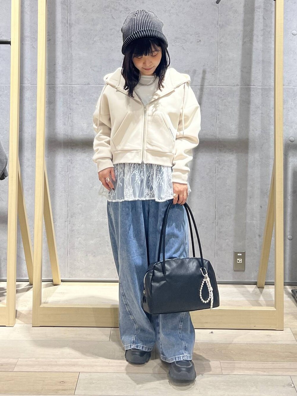 ホワイト系のTシャツ/カットソー、ブルー系のデニムパンツ、ブラック系のボストンバッグを着用したレディースの冬コーディネートの5枚目の写真