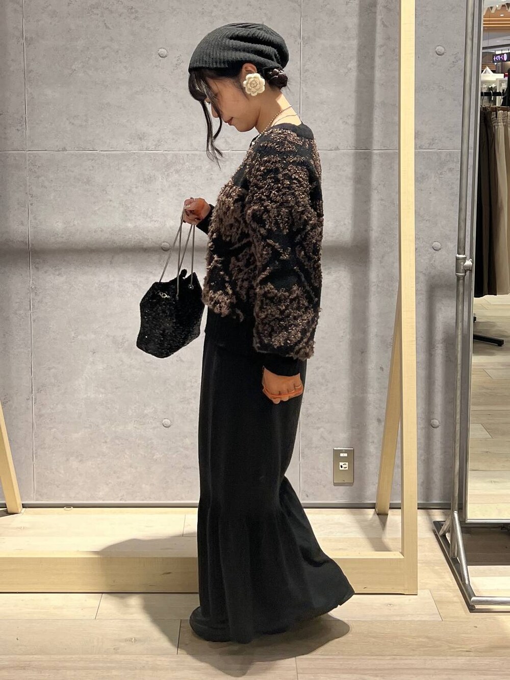 ブラック系のTシャツ/カットソー、ブラック系のスカート、ブラック系のショルダーバッグを着用したレディースの秋コーディネートの4枚目の写真