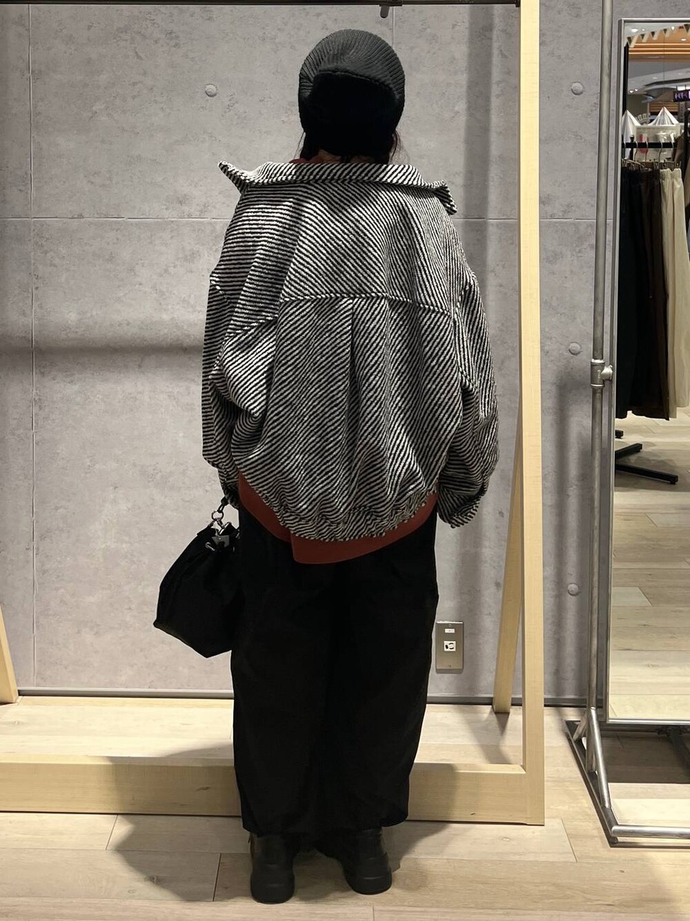 ブラック系のショルダーバッグ、ブラック系のその他パンツ、ブラック系のブルゾンを着用したレディースの秋コーディネートの3枚目の写真