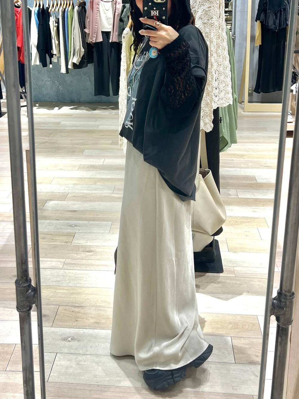 ブラウン系のボストンバッグ、グレー系のTシャツ/カットソー、ホワイト系のスカートを着用したレディースの春コーディネートの2枚目の写真