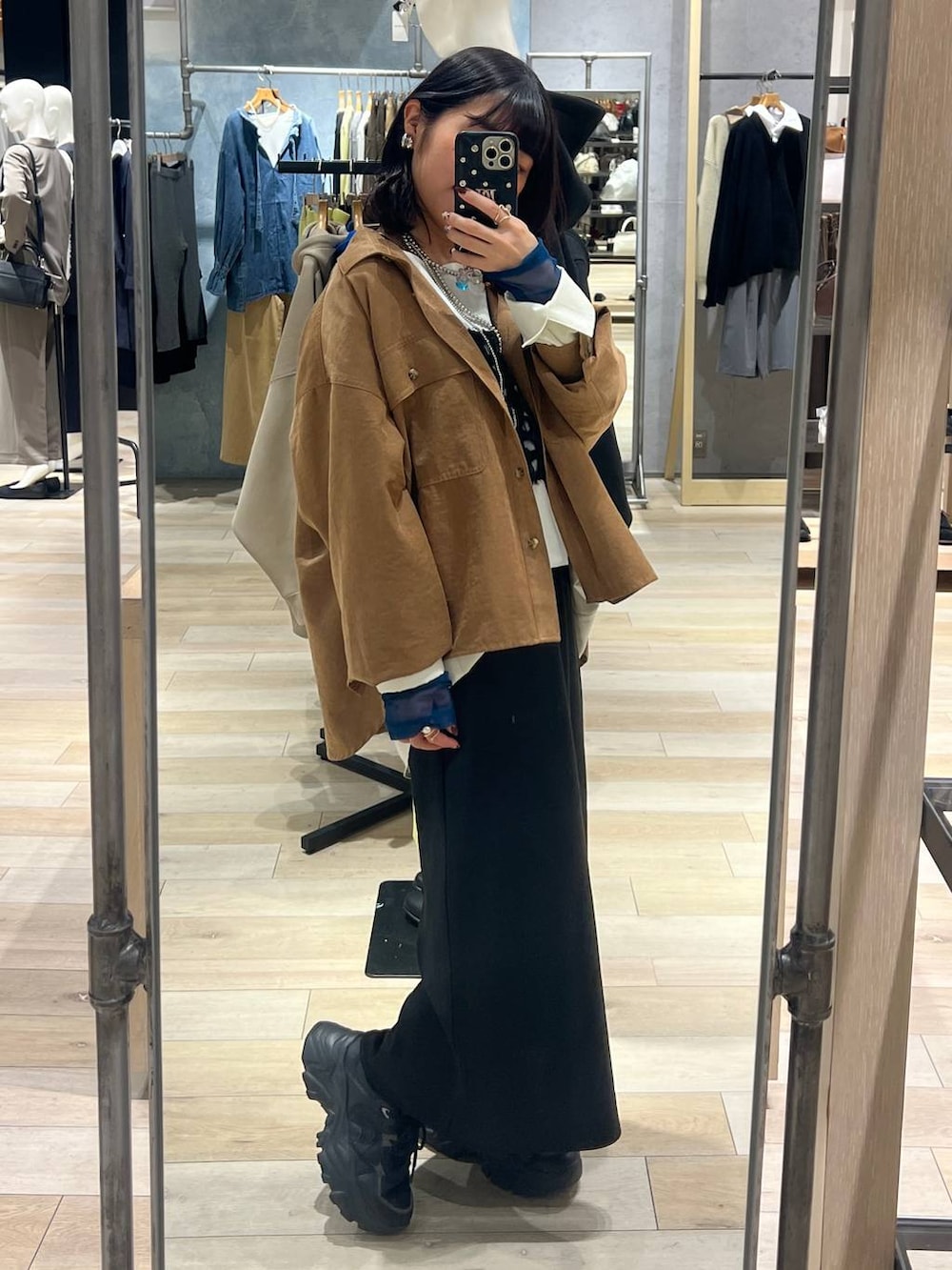 ブラック系のTシャツ/カットソー、ブラック系のスカート、イエロー系のシャツ/ブラウスを着用したレディースの冬コーディネートの2枚目の写真