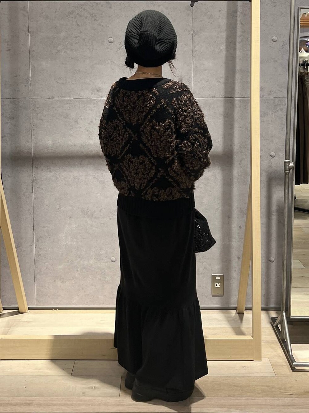 ブラック系のTシャツ/カットソー、ブラック系のスカート、ブラック系のショルダーバッグを着用したレディースの秋コーディネートの3枚目の写真