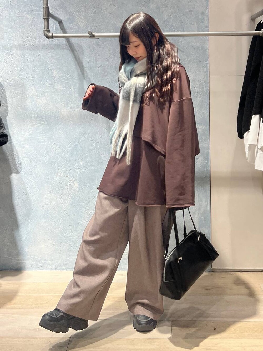 ブラック系のボストンバッグ、ブラウン系のスウェット、ブラウン系のその他パンツを着用したレディースの冬コーディネートの2枚目の写真