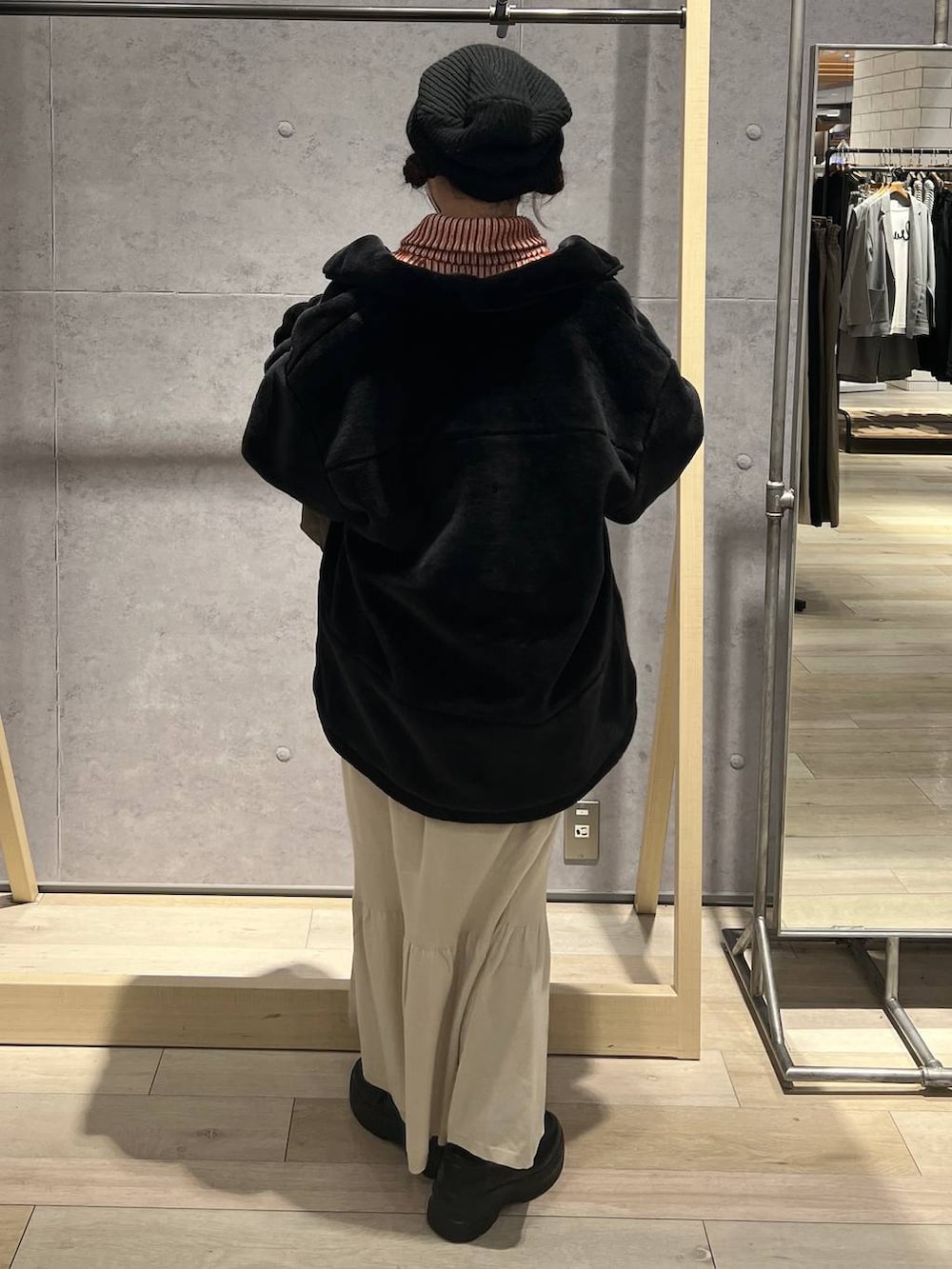 ブラウン系のショルダーバッグ、ホワイト系のスカート、オレンジ系のカーディガン/ボレロを着用したレディースの秋コーディネートの3枚目の写真