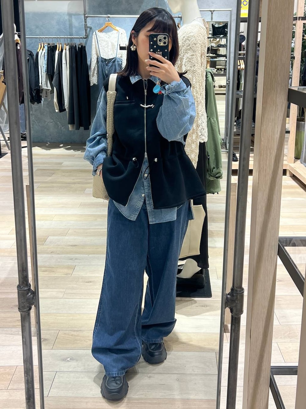 ブルー系のデニムパンツ、ブルー系のシャツ/ブラウス、ブラック系のベストを着用したレディースの春コーディネートの4枚目の写真