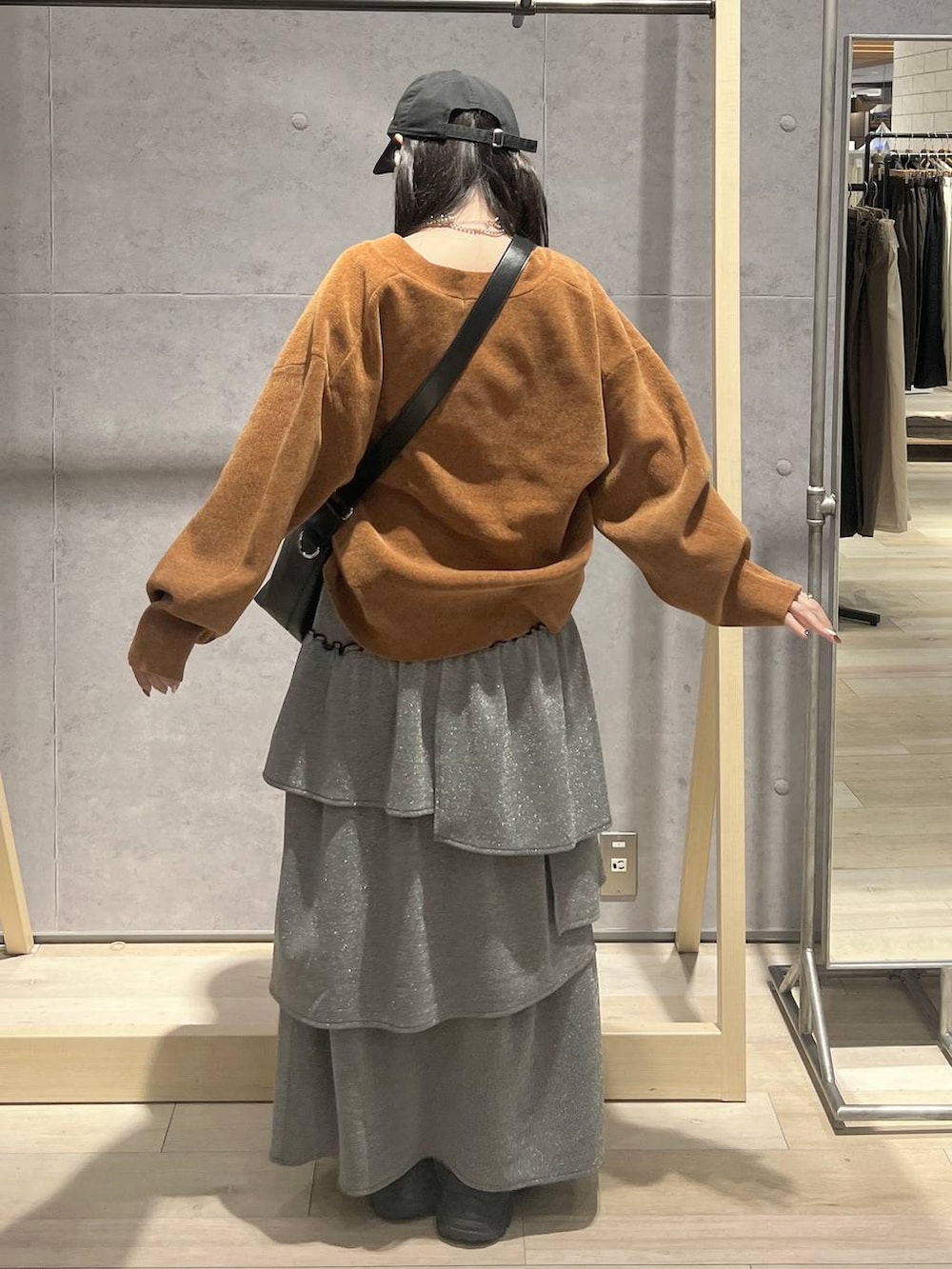 ブラック系のショルダーバッグ、イエロー系のカーディガン/ボレロ、グレー系のスカートを着用したレディースの秋コーディネートの3枚目の写真