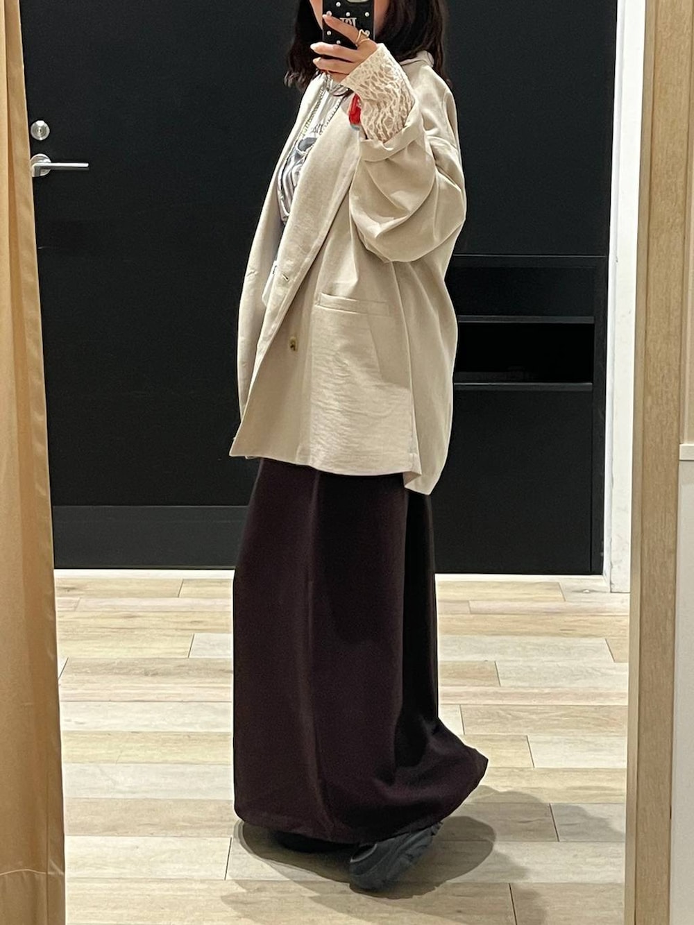 ブラック系のショルダーバッグ、ブラウン系のスカート、ホワイト系のTシャツ/カットソーを着用したレディースの春コーディネートの2枚目の写真