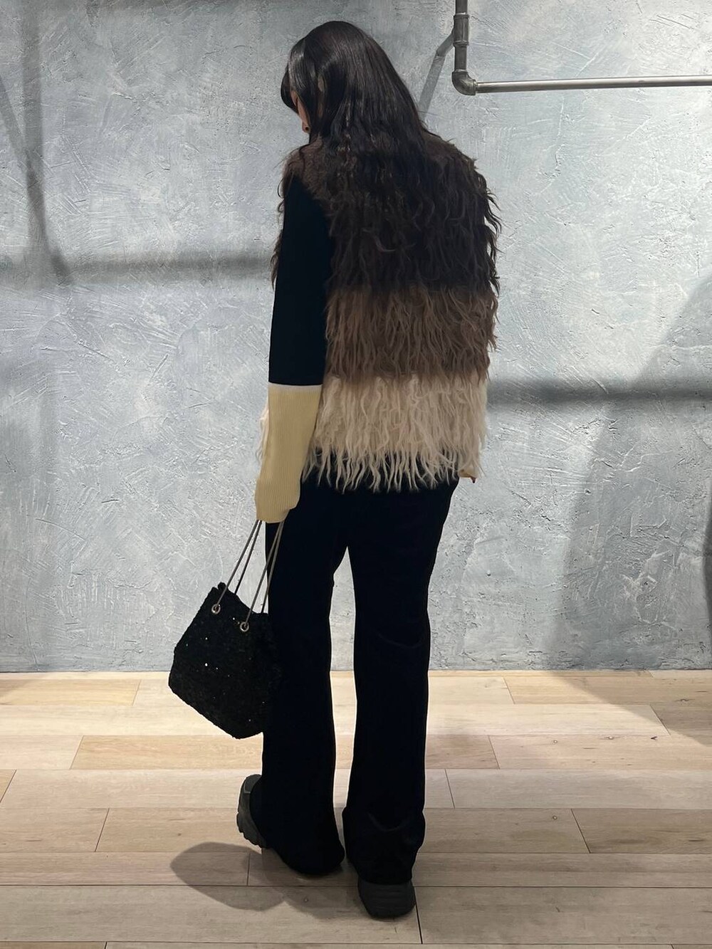 ブラック系のニット/セーター、ブラック系のその他パンツ、ブラック系のショルダーバッグを着用したレディースの冬コーディネートの4枚目の写真