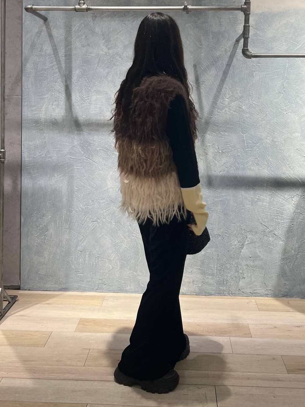 ブラック系のニット/セーター、ブラック系のその他パンツ、ブラック系のショルダーバッグを着用したレディースの冬コーディネートの2枚目の写真