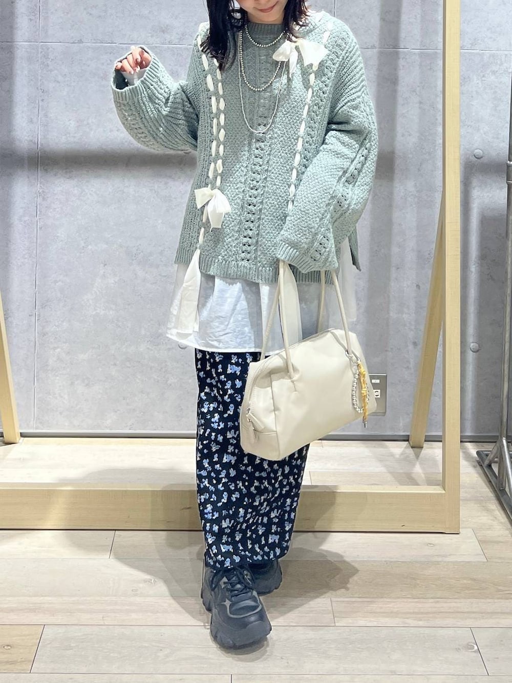 ホワイト系のTシャツ/カットソー、ホワイト系のボストンバッグ、ブラック系のスカートを着用したレディースの冬コーディネートの4枚目の写真