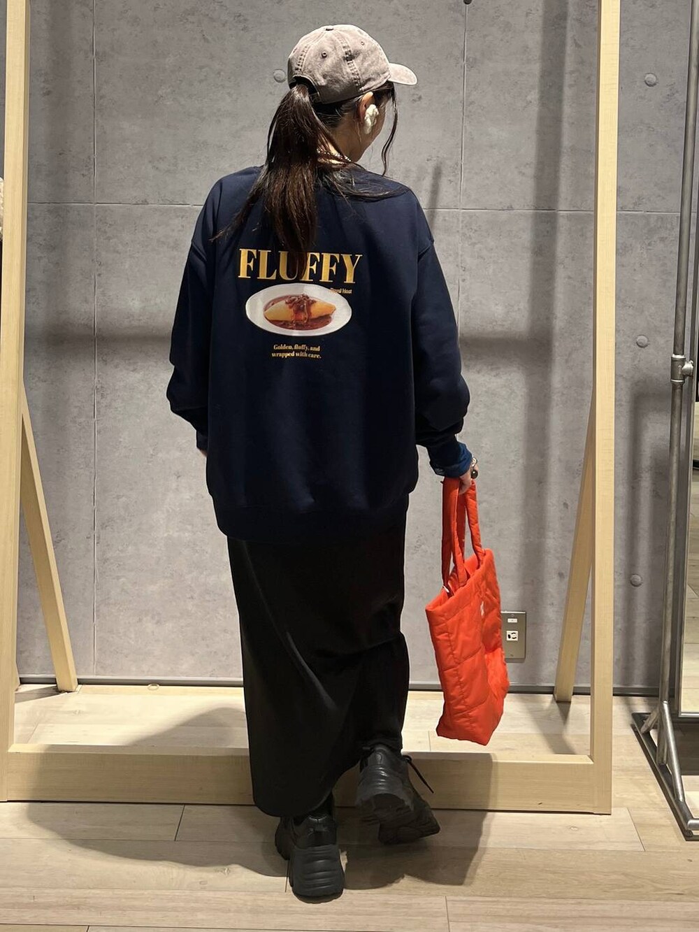 ブラック系のTシャツ/カットソー、ブラック系のスカート、ブルー系のスウェットを着用したレディースの秋コーディネートの5枚目の写真