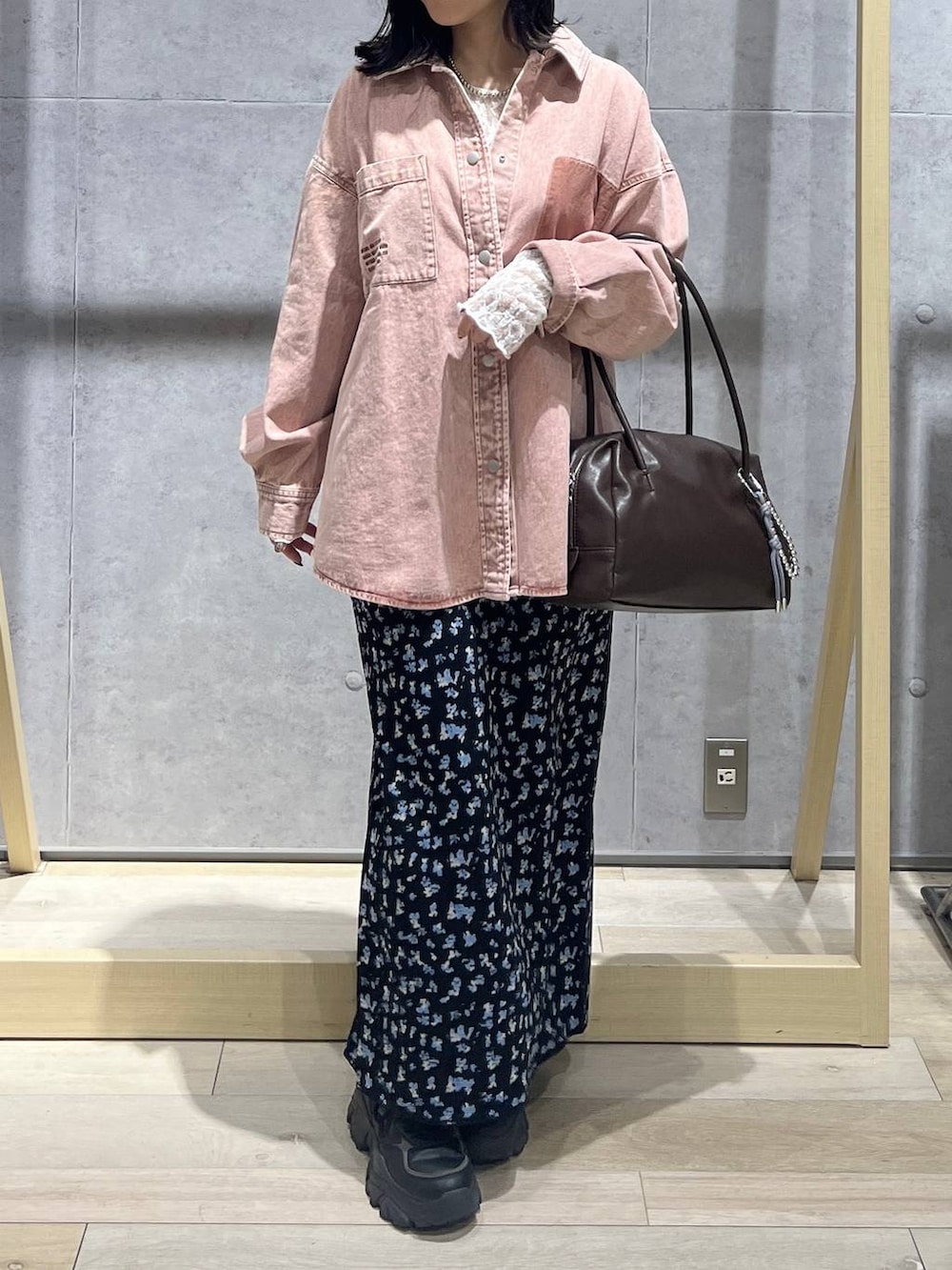 ピンク系のシャツ/ブラウス、ブラウン系のボストンバッグ、ブラック系のスカートを着用したレディースの冬コーディネートの6枚目の写真