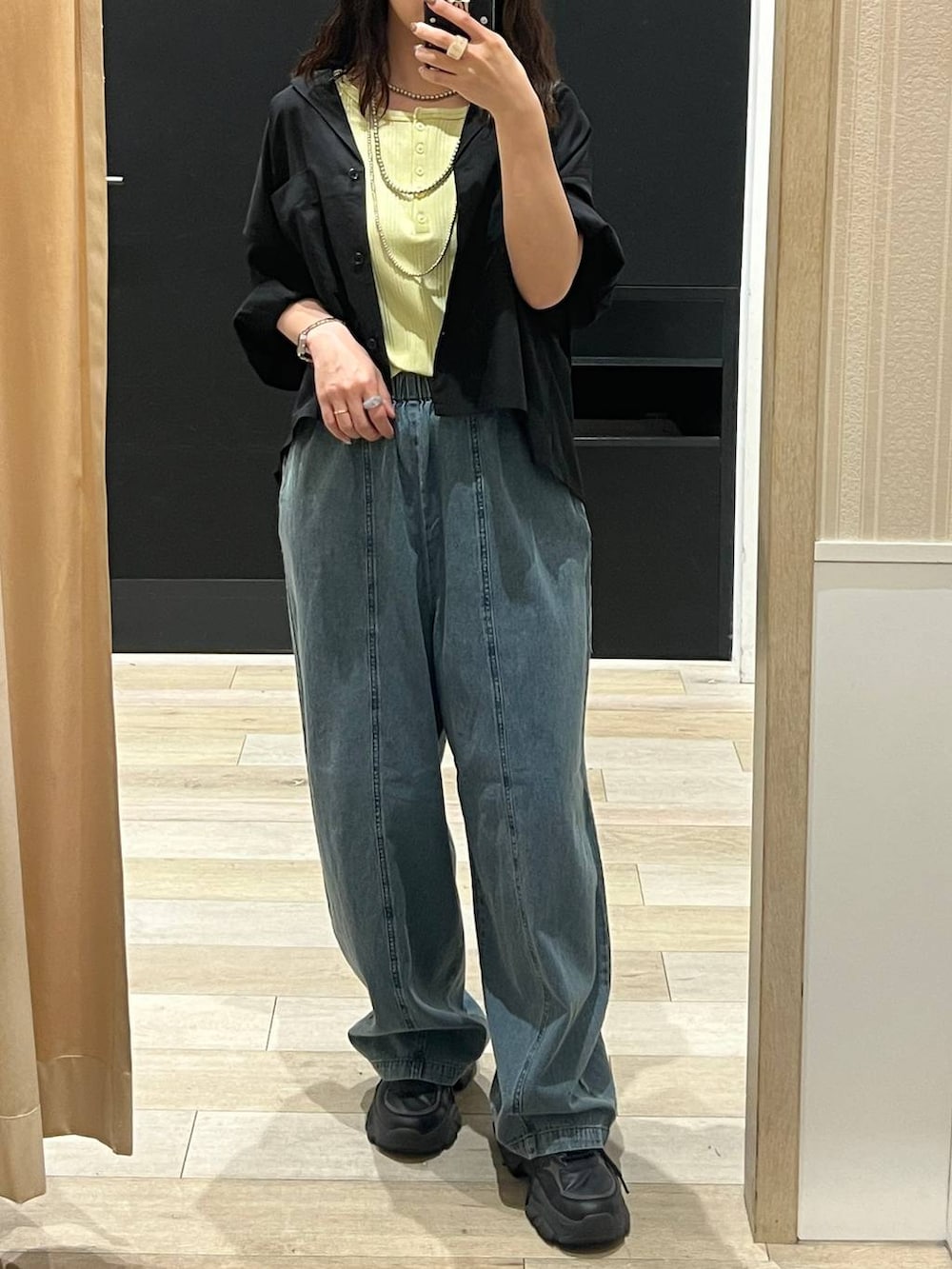 ブルー系のデニムパンツ、ブラック系のシャツ/ブラウス、シルバー系のネックレスを着用したレディースの春コーディネートの3枚目の写真