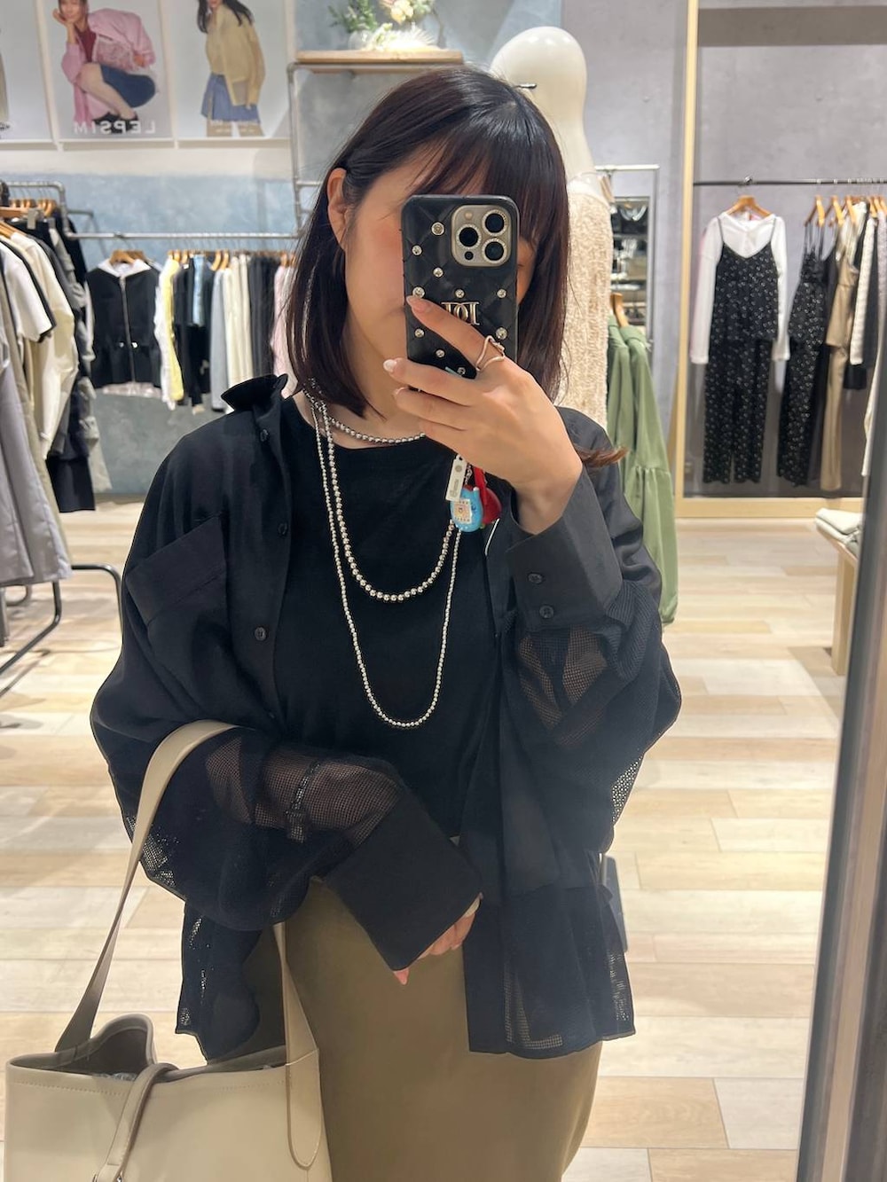 グリーン系のスカート、ホワイト系のトートバッグ、ブラック系のシャツ/ブラウスを着用したレディースの春コーディネートの3枚目の写真