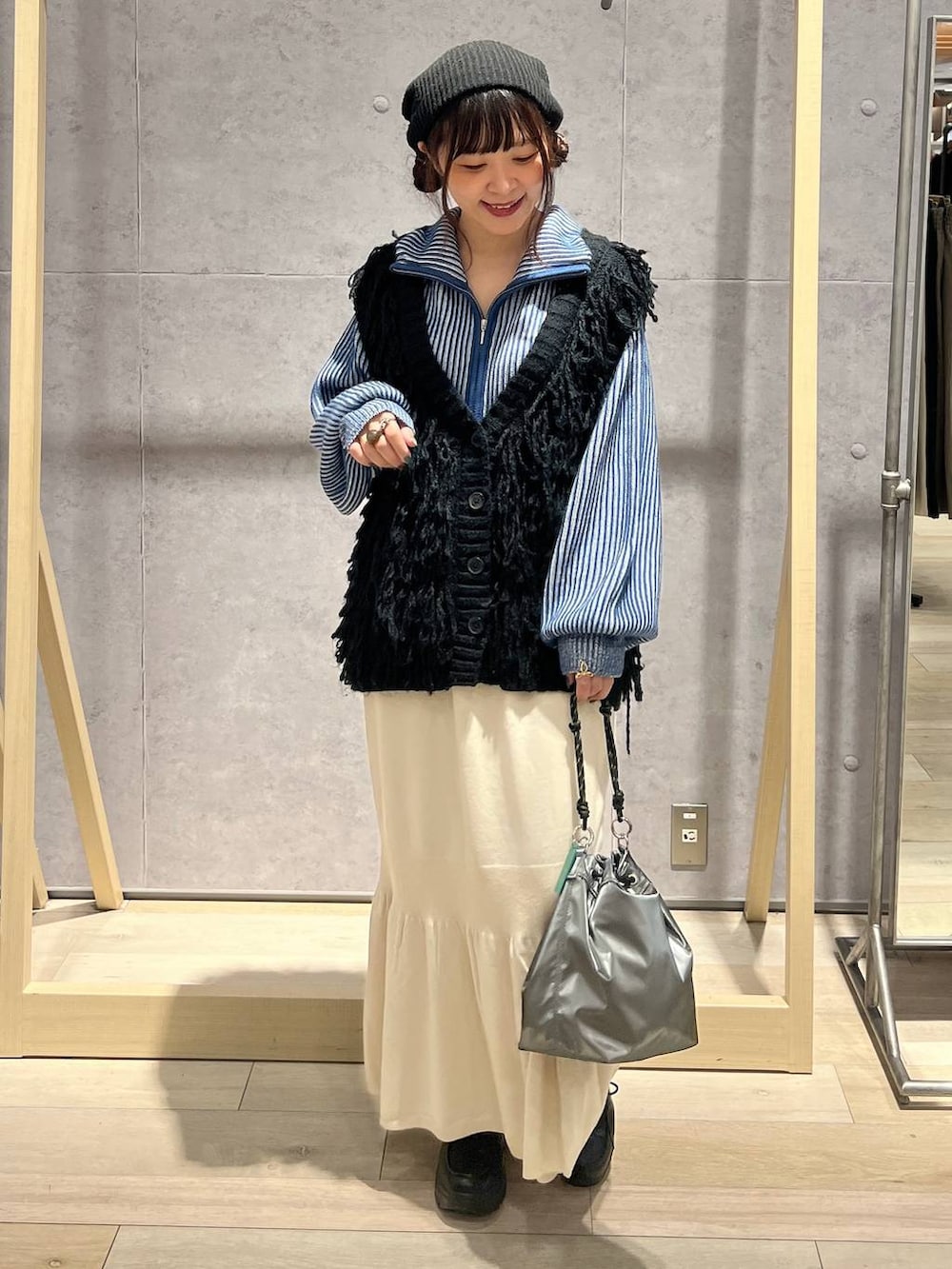 その他のショルダーバッグ、ホワイト系のスカート、ブルー系のカーディガン/ボレロを着用したレディースの秋コーディネートの4枚目の写真