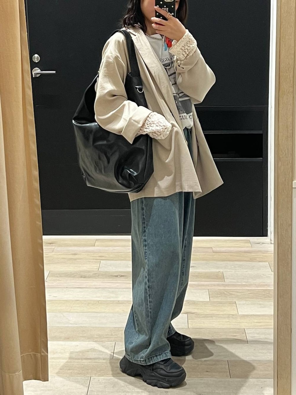 ベージュ系のテーラードジャケット、ブラック系のショルダーバッグ、ホワイト系のTシャツ/カットソーを着用したレディースの春コーディネートの2枚目の写真