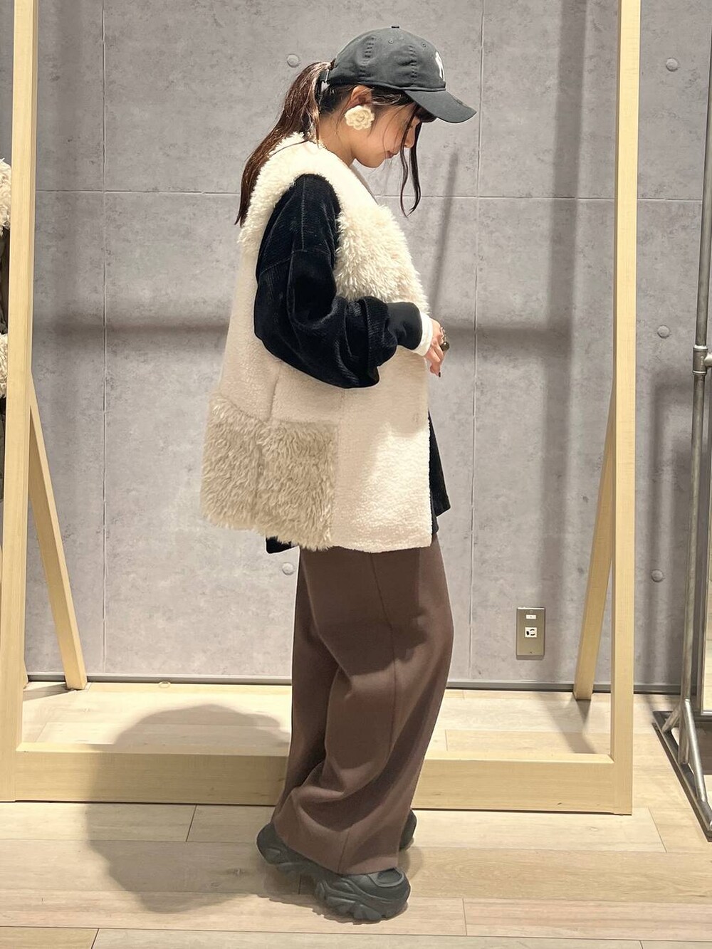 ブラウン系のその他パンツ、ホワイト系のベスト、ブラック系のTシャツ/カットソーを着用したレディースの秋コーディネートの2枚目の写真