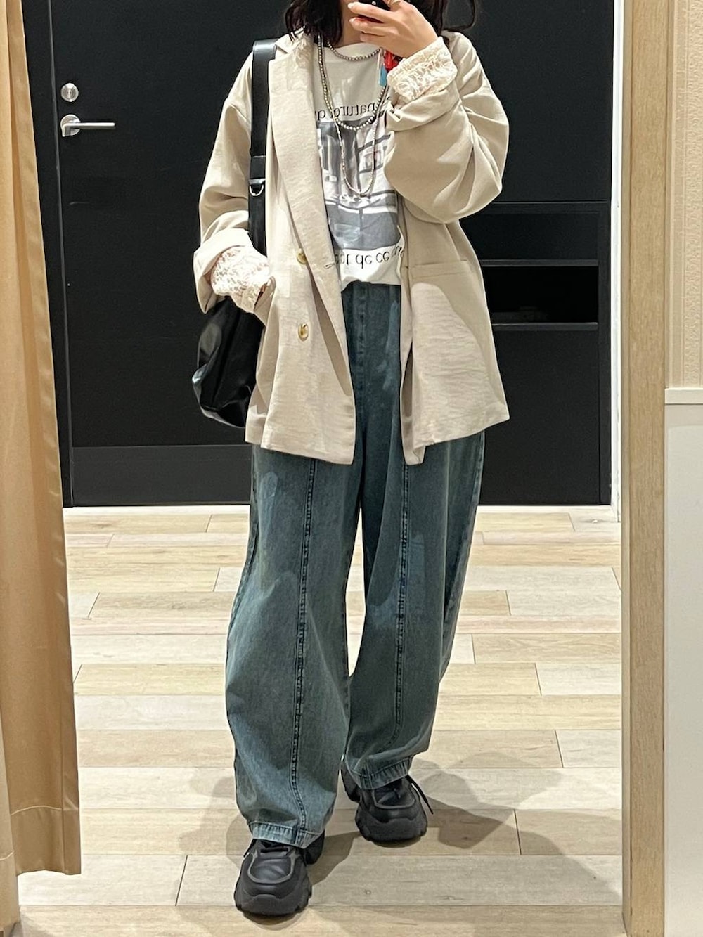 ベージュ系のテーラードジャケット、ブラック系のショルダーバッグ、ホワイト系のTシャツ/カットソーを着用したレディースの春コーディネートの3枚目の写真