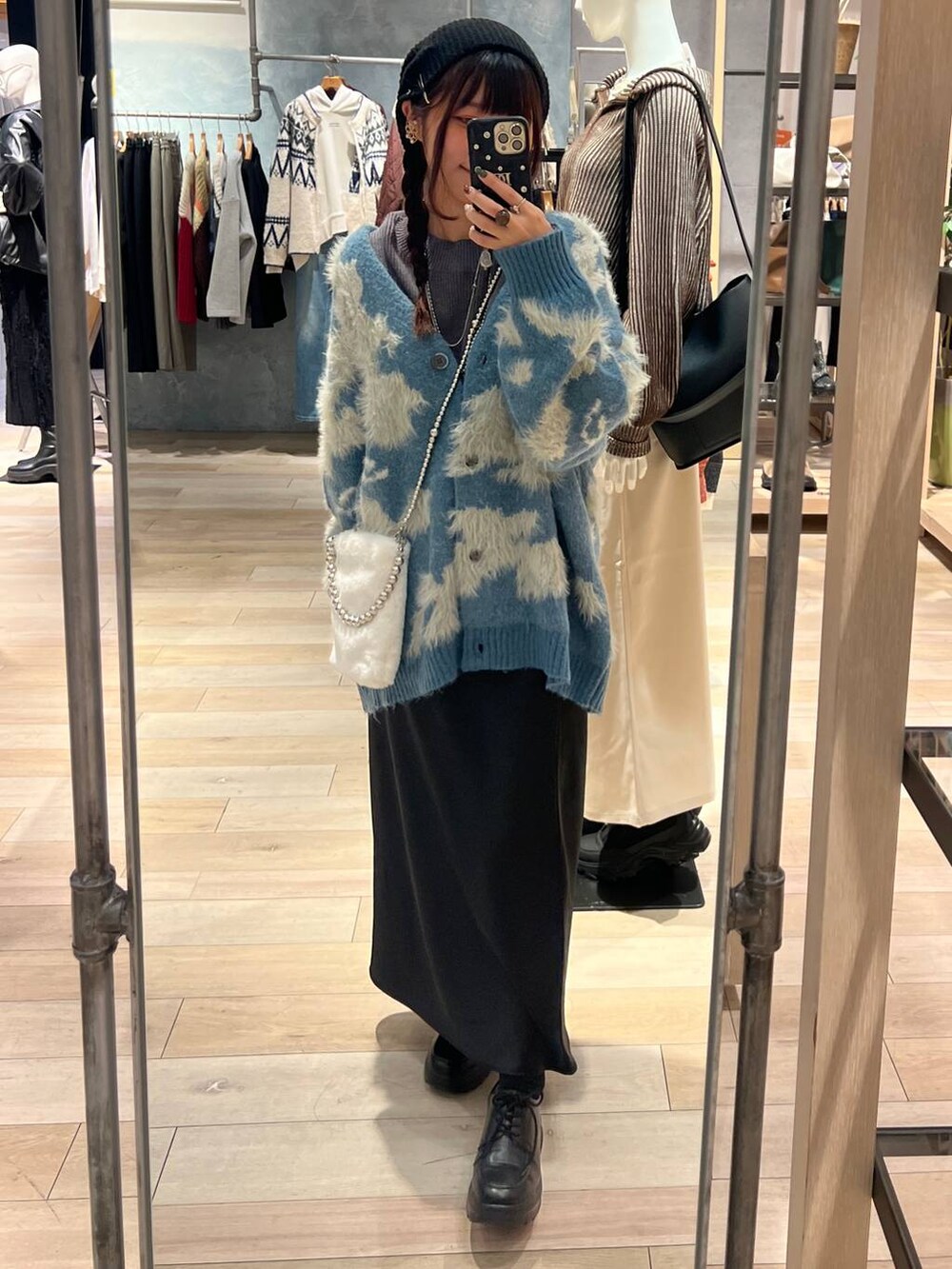 ブラック系のスカート、グレー系のニット/セーター、ホワイト系のショルダーバッグを着用したレディースの秋コーディネートの4枚目の写真