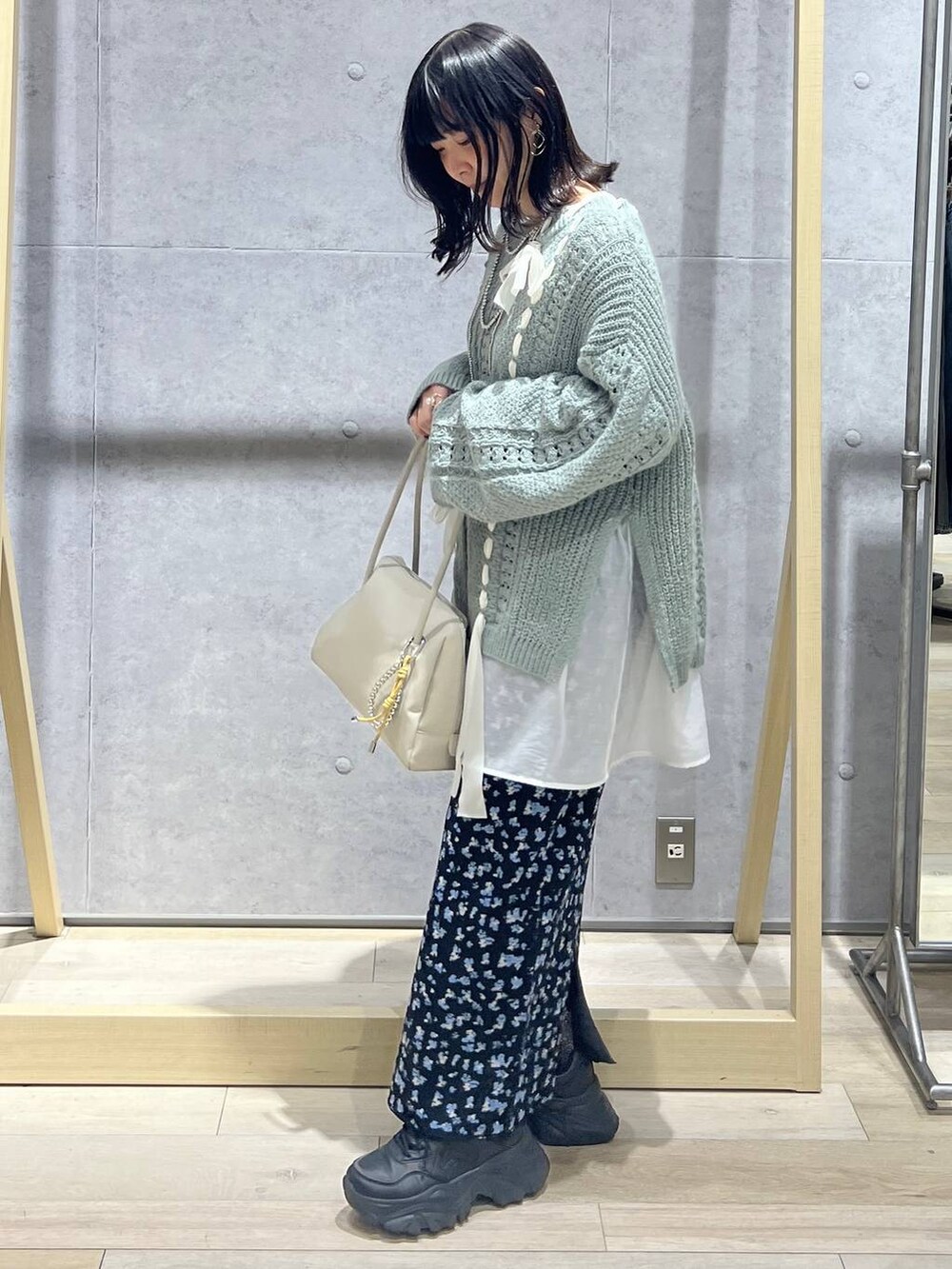 ホワイト系のTシャツ/カットソー、ホワイト系のボストンバッグ、ブラック系のスカートを着用したレディースの冬コーディネートの2枚目の写真