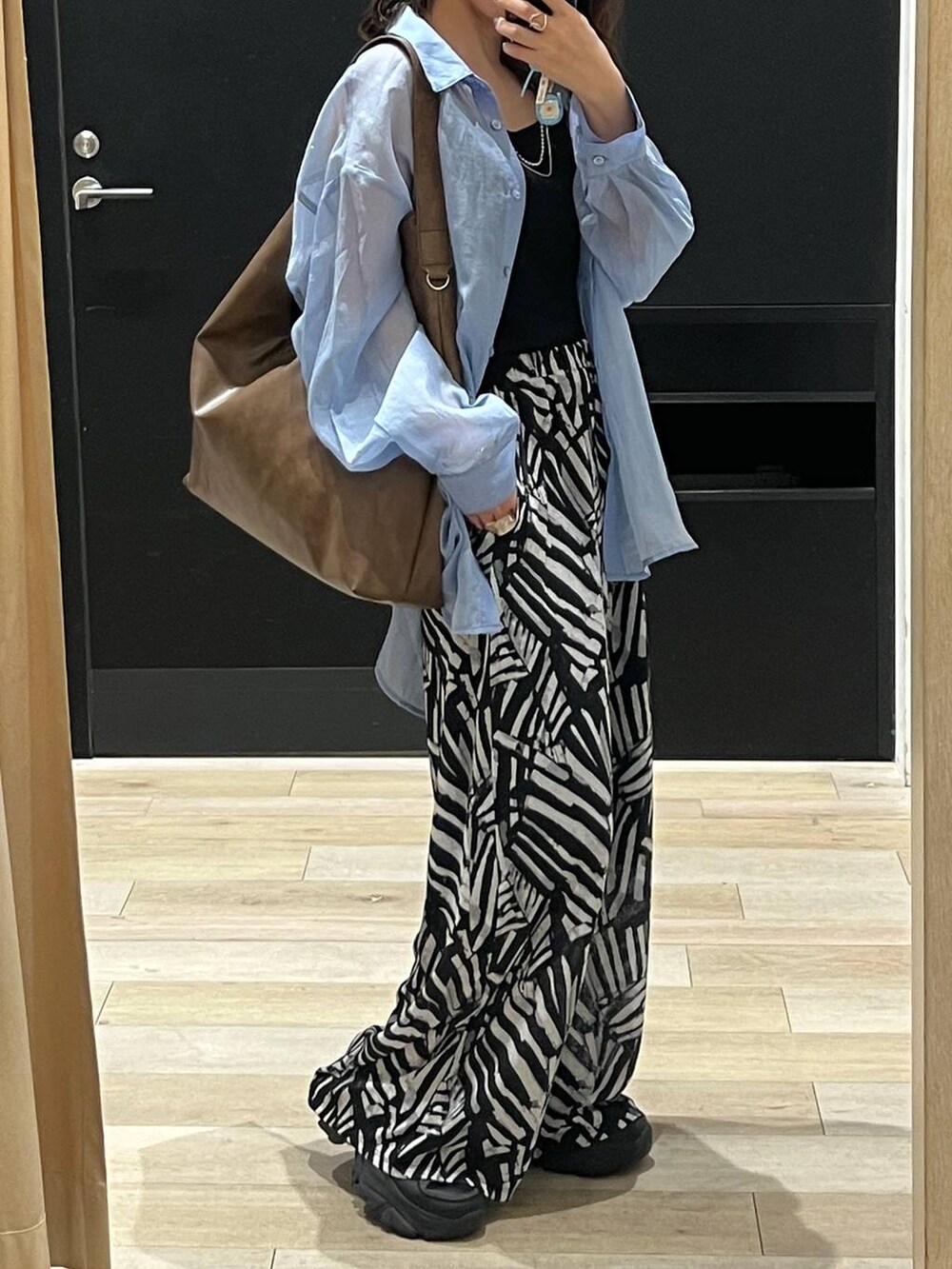 ブルー系のシャツ/ブラウス、ブラック系のその他パンツ、ブラウン系のショルダーバッグを着用したレディースの春コーディネートの2枚目の写真