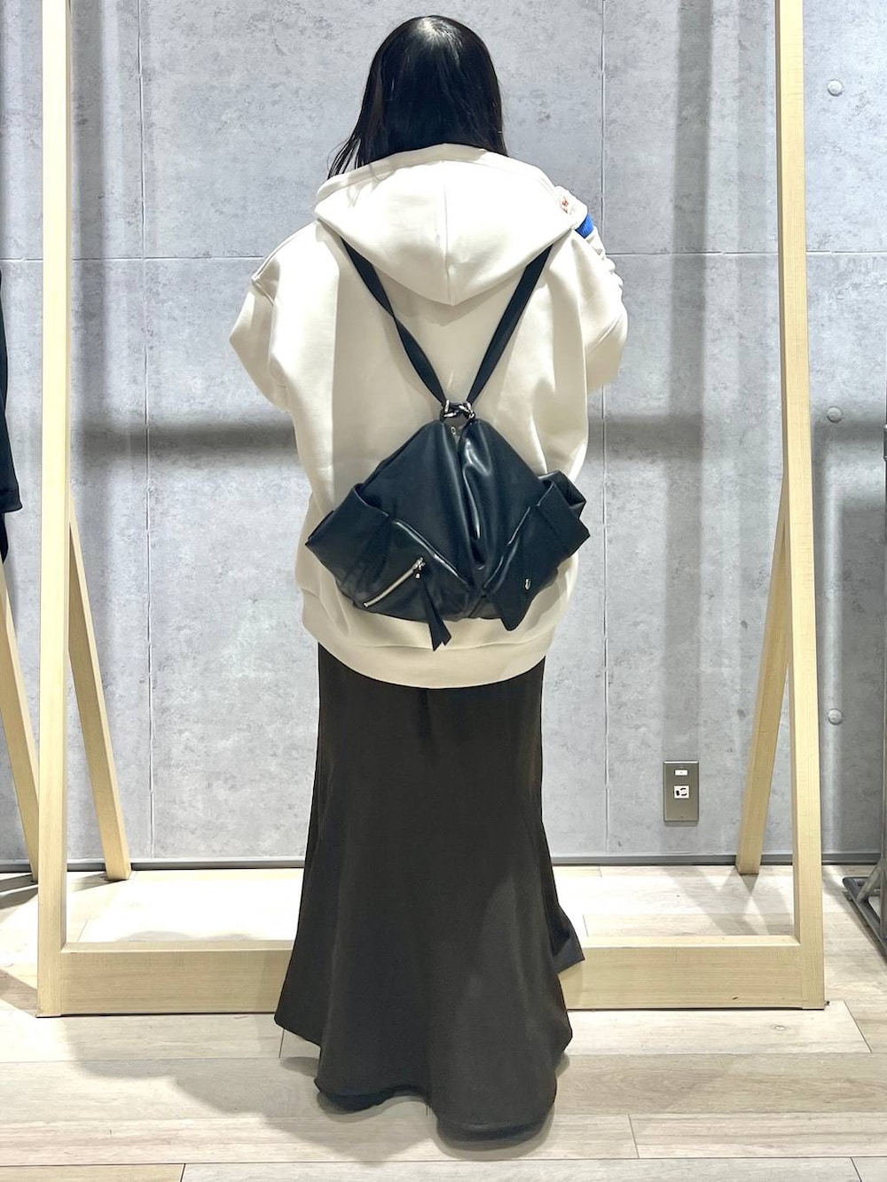 ホワイト系のパーカー、ブラック系のショルダーバッグ、ブラウン系のスカートを着用したレディースの春コーディネートの4枚目の写真