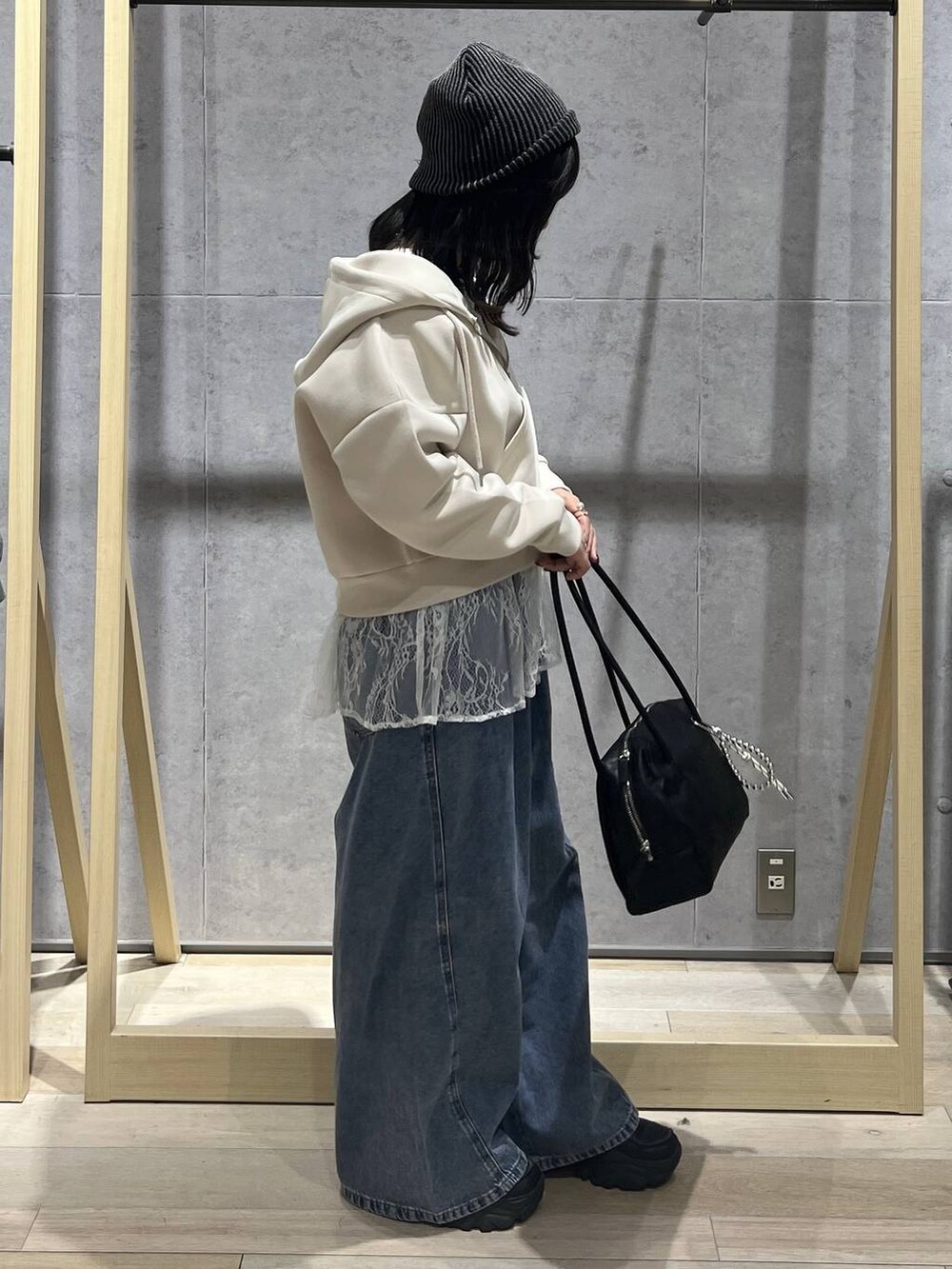 ホワイト系のTシャツ/カットソー、ブルー系のデニムパンツ、ブラック系のボストンバッグを着用したレディースの冬コーディネートの4枚目の写真